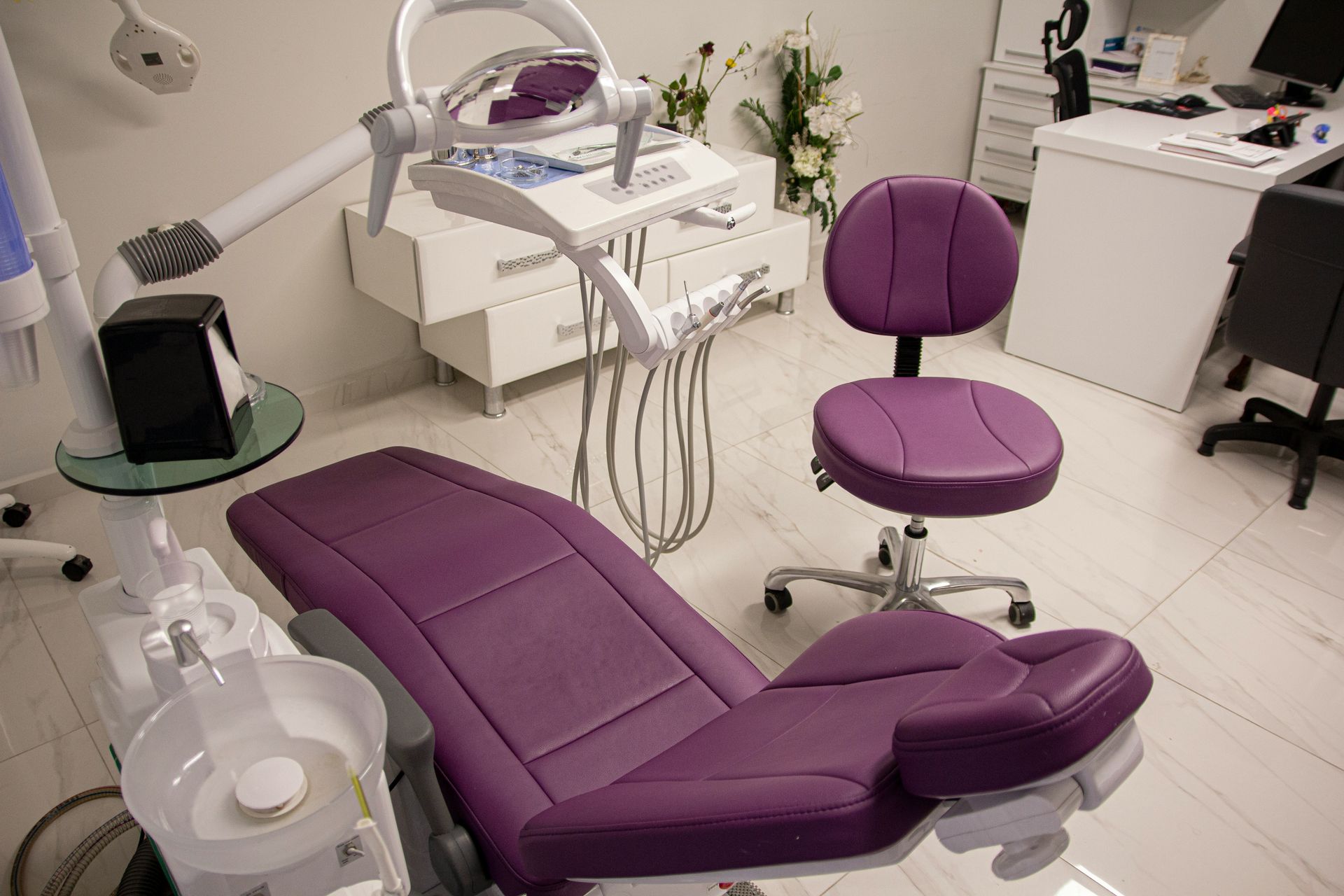 Purple dental chair and stool in a modern dental office.