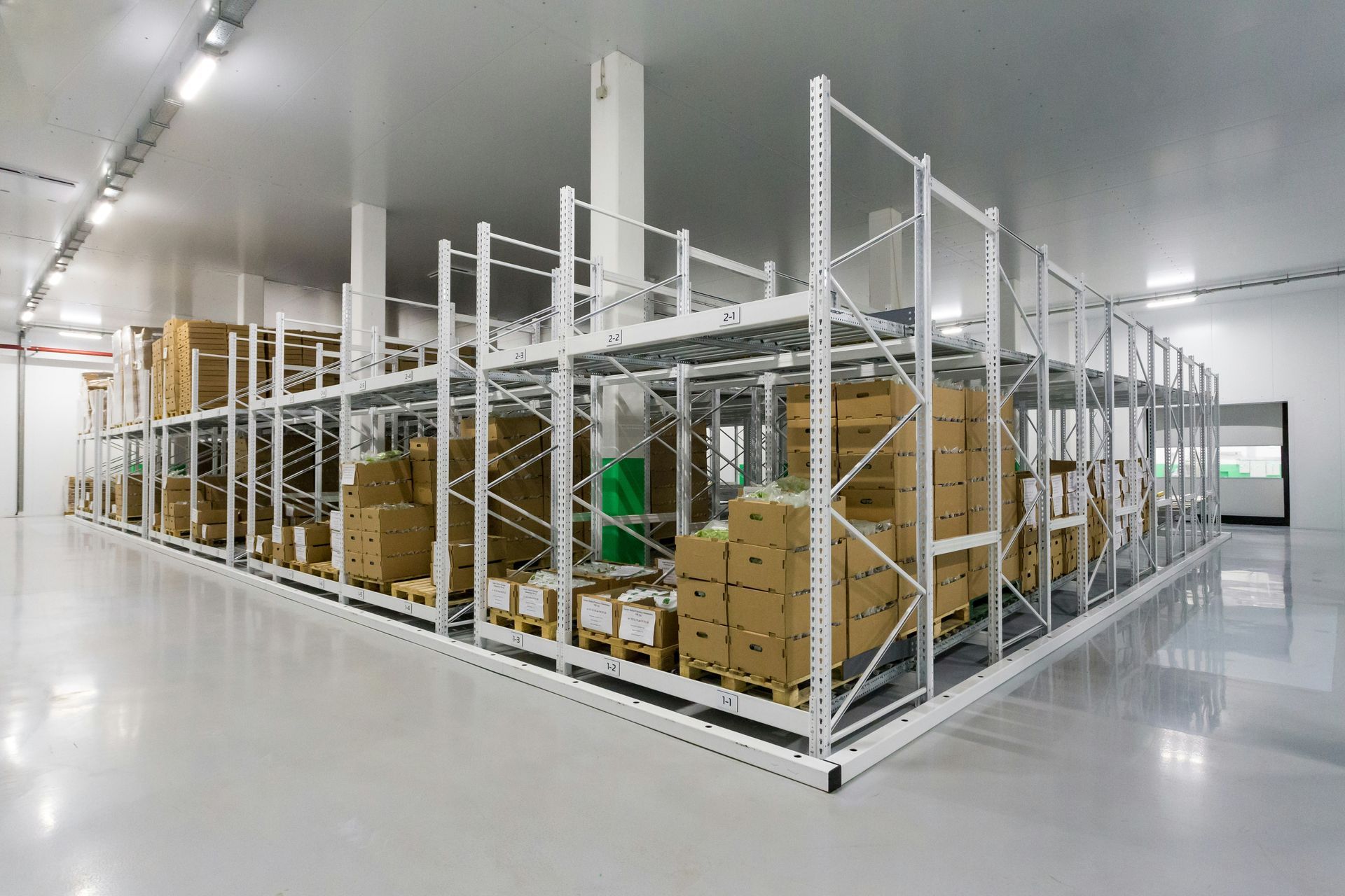 Warehouse interior with metal shelving holding cardboard boxes and products.