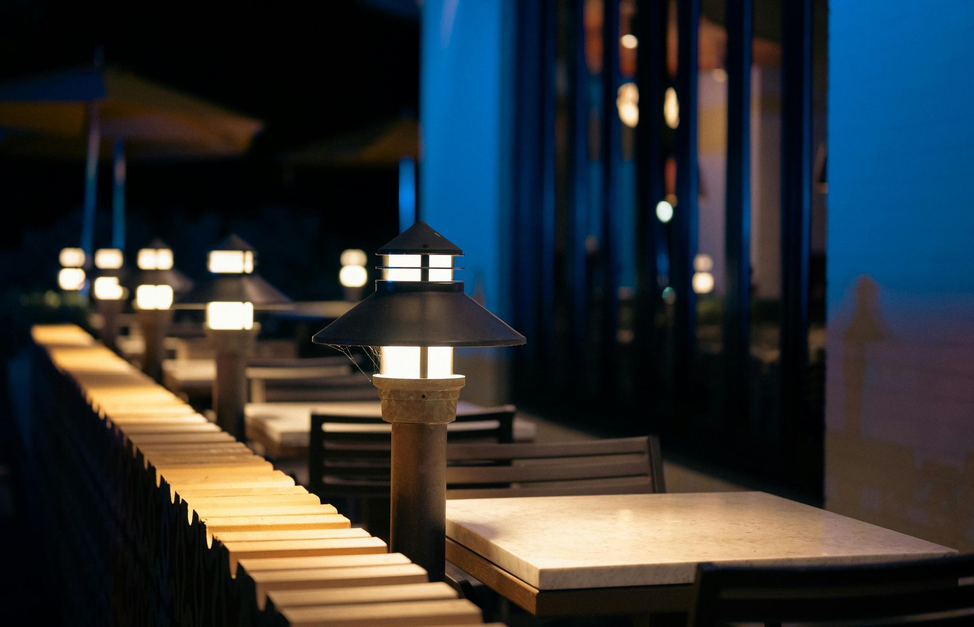 Boise Bar interior with stools, a long counter, and shelves filled with bottles, lit by amber lights.