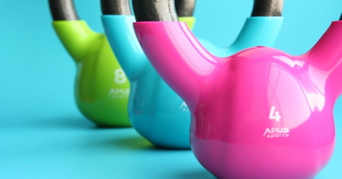 Three colorful kettlebells: green, blue, and pink.