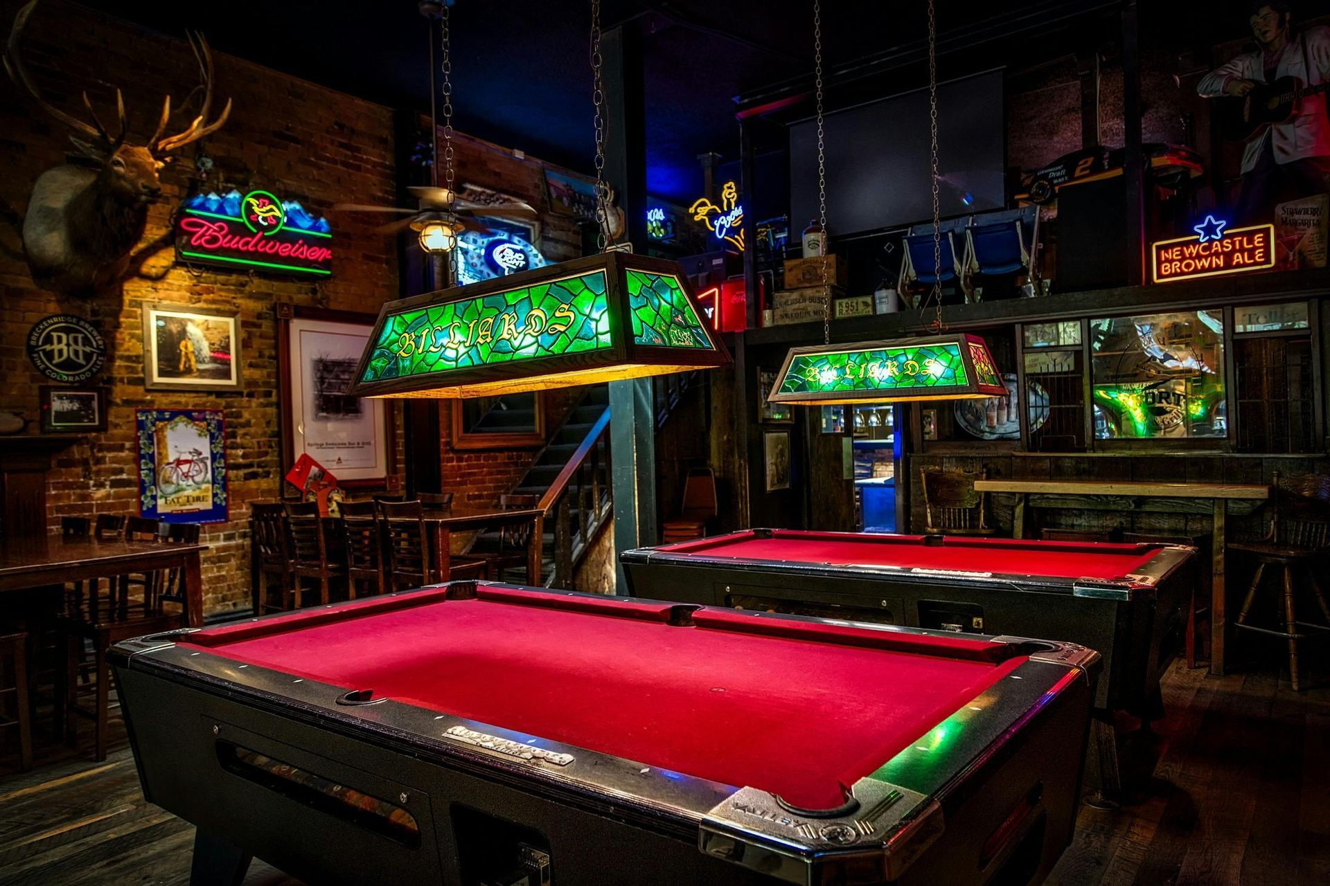 Boise Bar interior with stools, a long counter, and shelves filled with bottles, lit by amber lights.