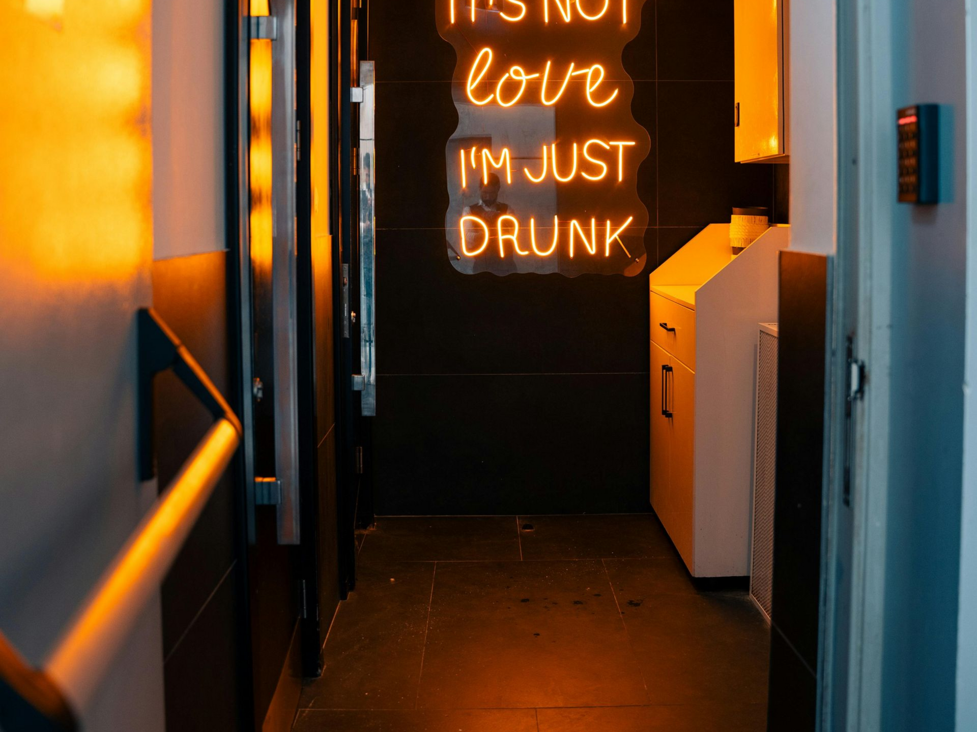 Boise Bar counter with liquor bottles and a Havana Club sign, bathed in red and purple lights.