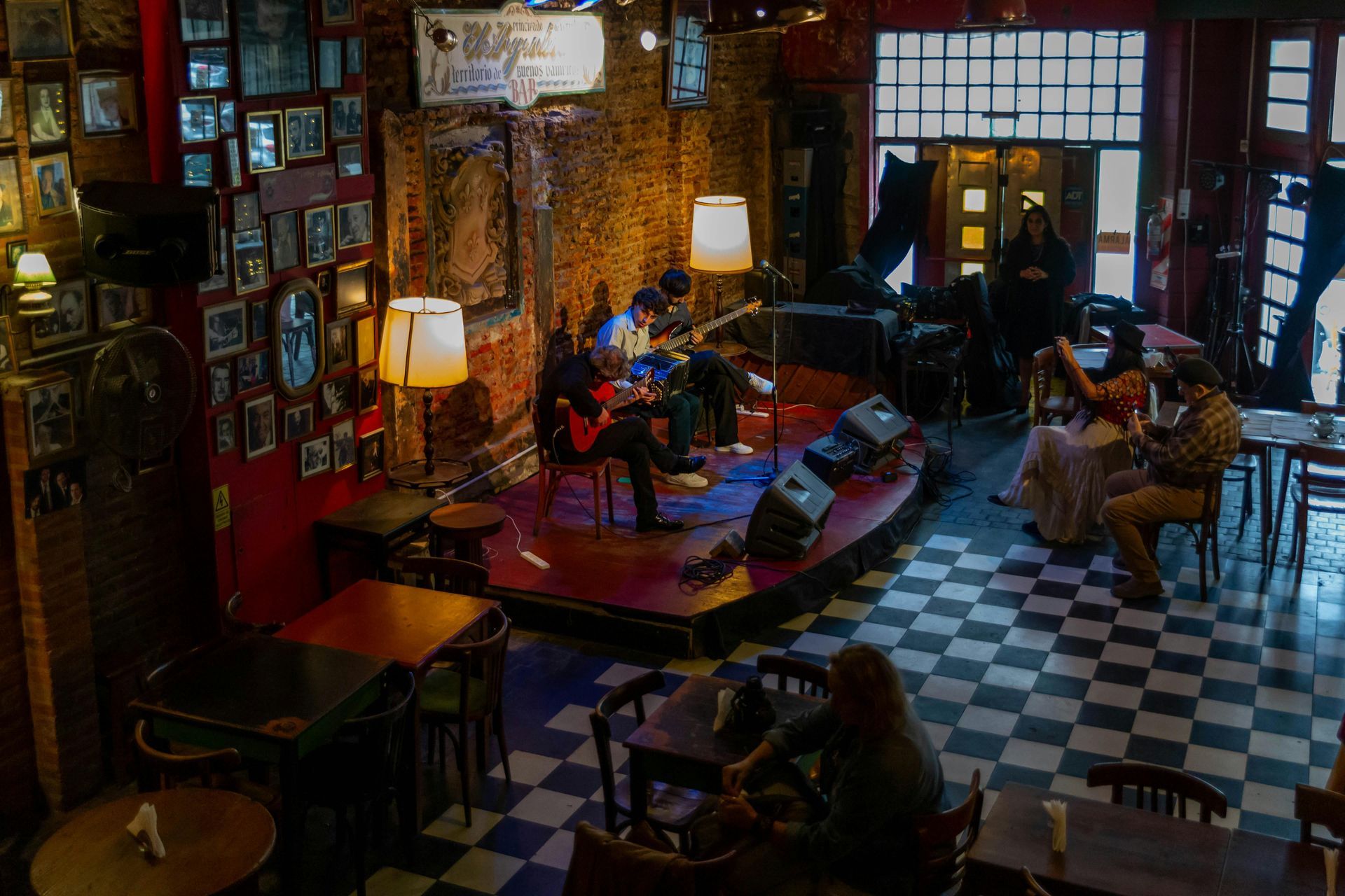 Boise Bar interior with stools, a long counter, and shelves filled with bottles, lit by amber lights.