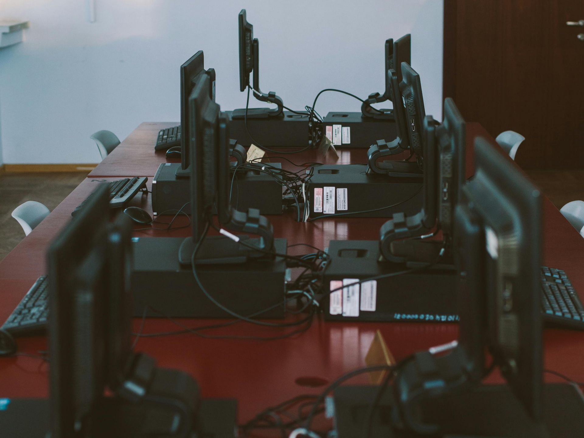 Two women at a table in a bright office. Grey sofa, round table, and big windows.