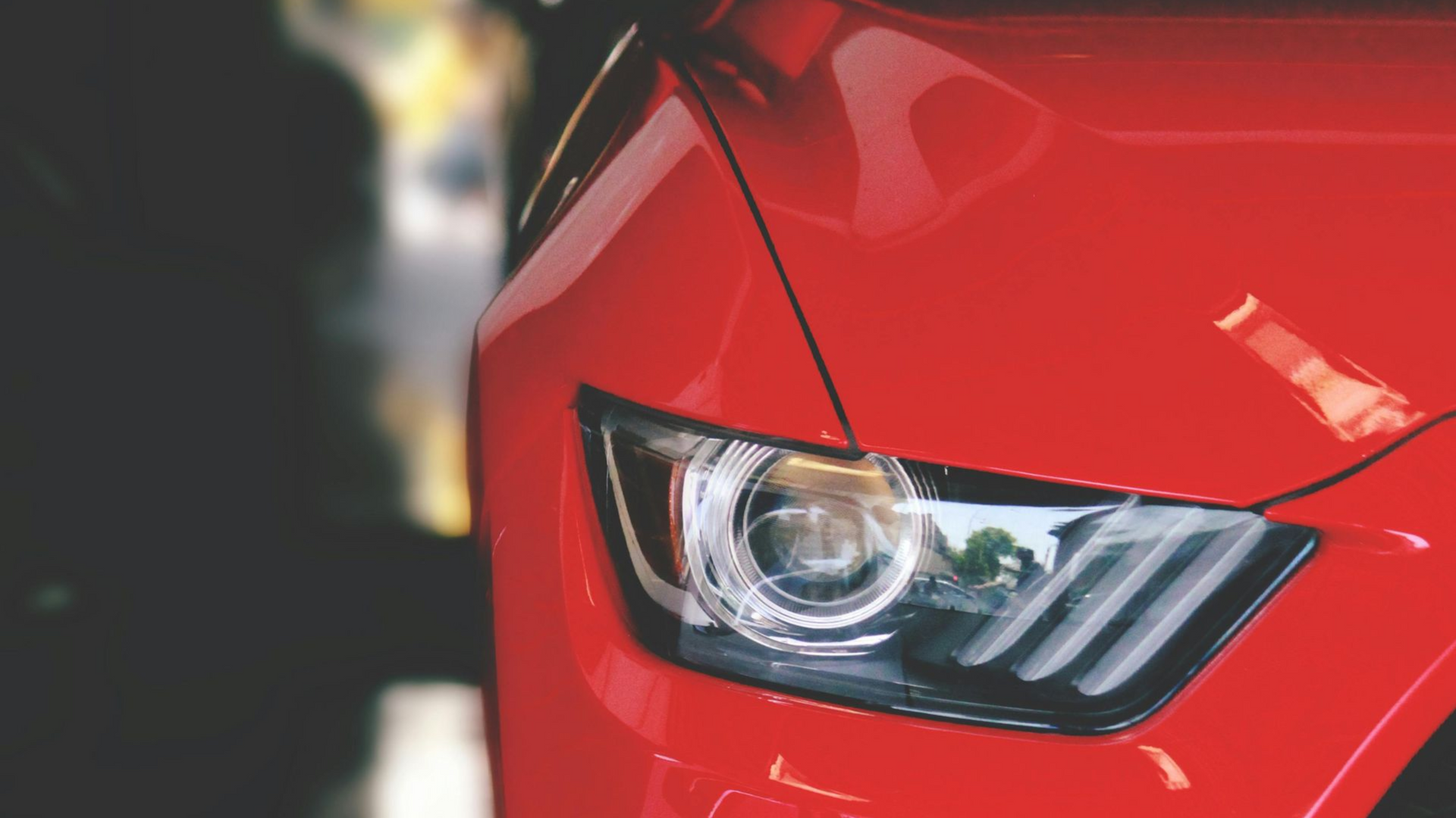 Red sports car's headlight and front quarter panel in Eagle, clean and shined by Noble Clean.