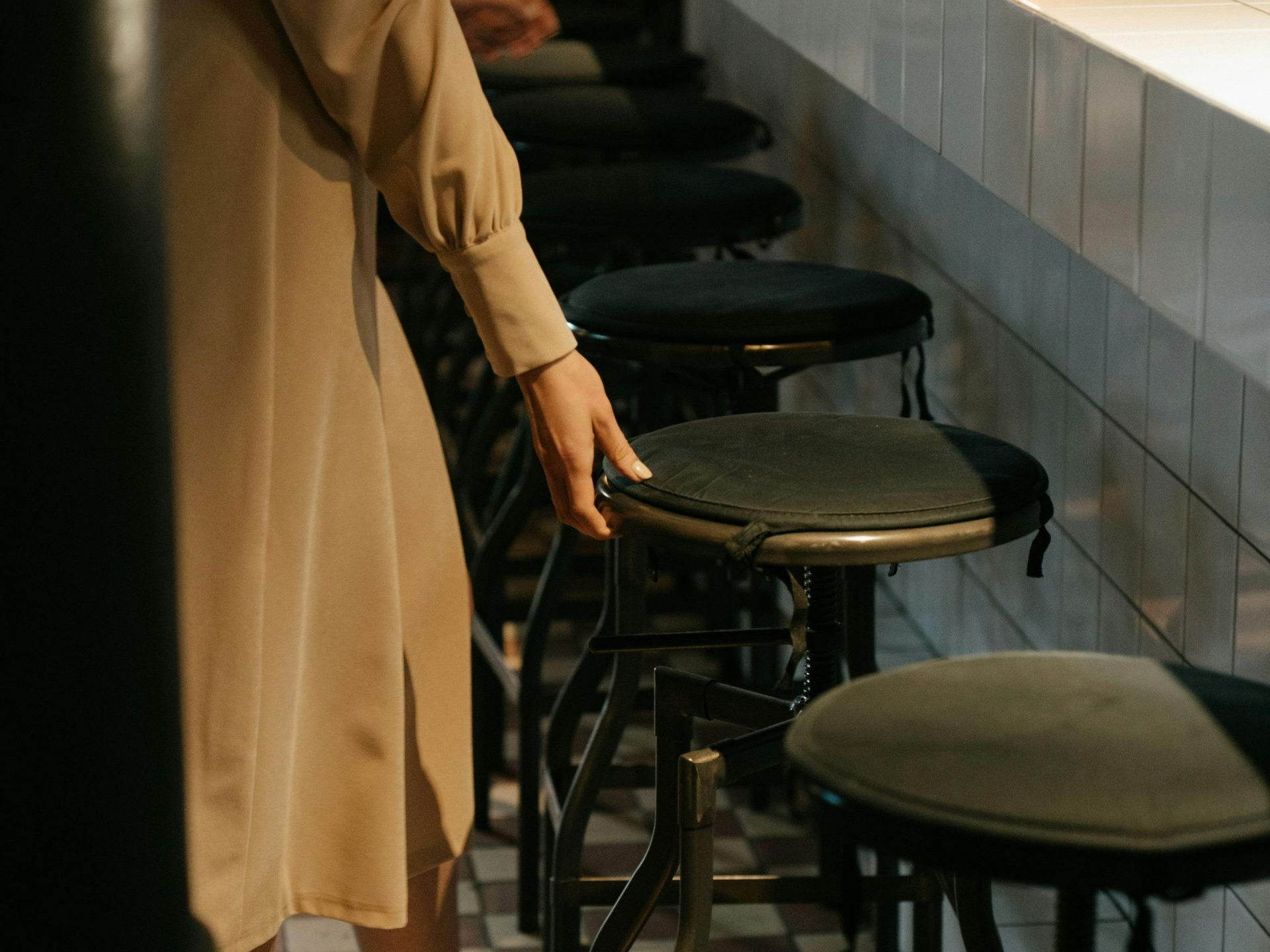 Boise Bar interior with stools, a long counter, and shelves filled with bottles, lit by amber lights.