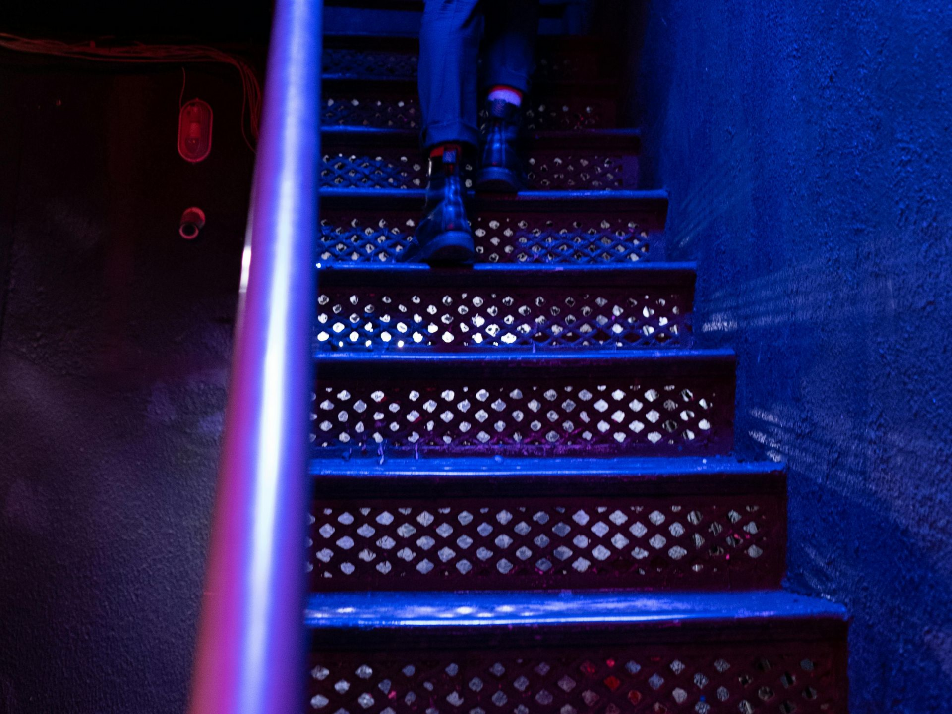 Boise Bar interior with stools, a long counter, and shelves filled with bottles, lit by amber lights.