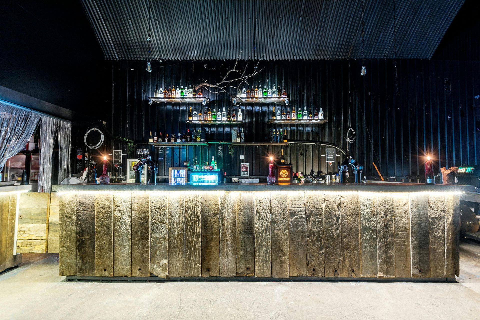 Boise Bar counter with liquor bottles and a Havana Club sign, bathed in red and purple lights.
