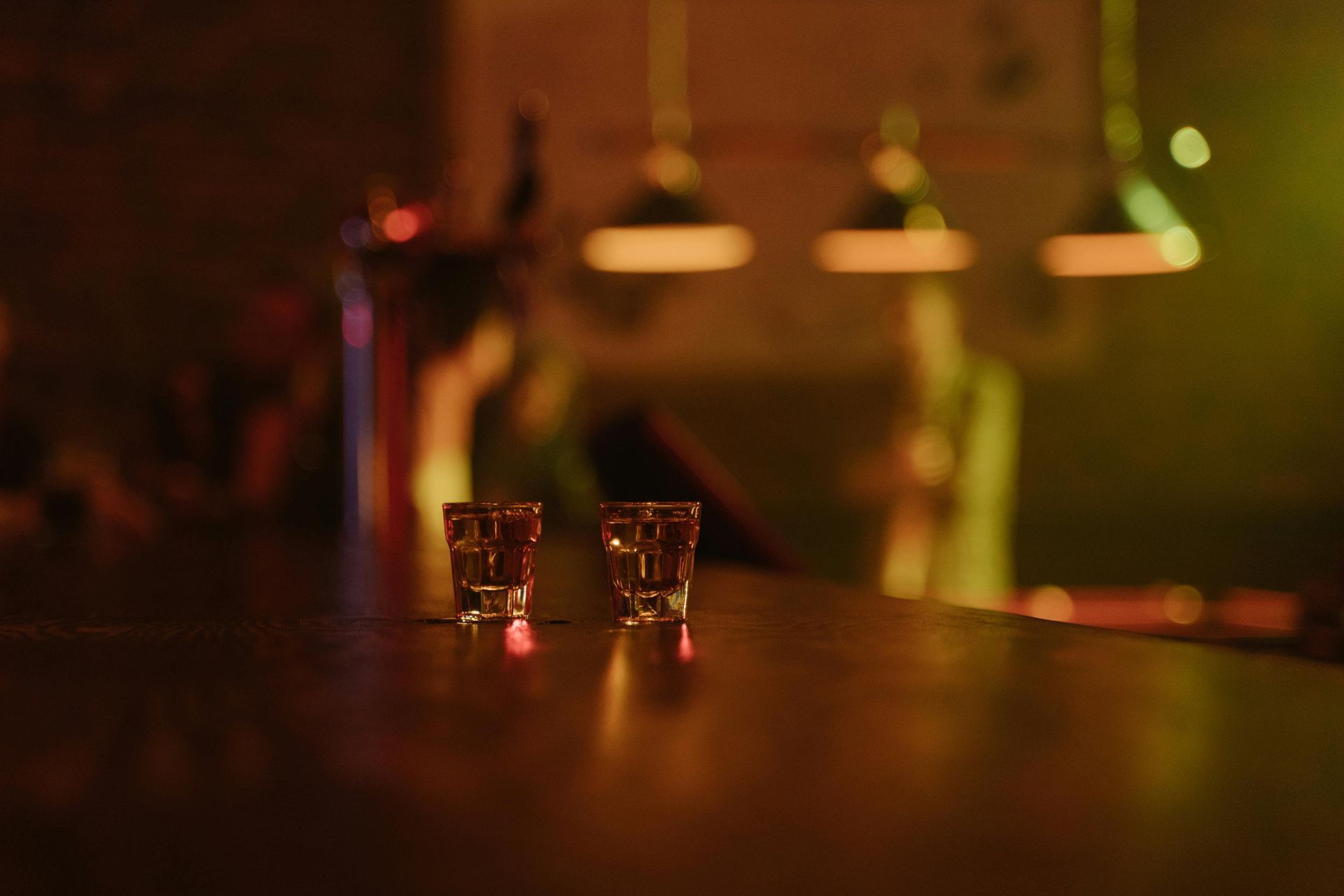 Boise Bar counter with liquor bottles and a Havana Club sign, bathed in red and purple lights.