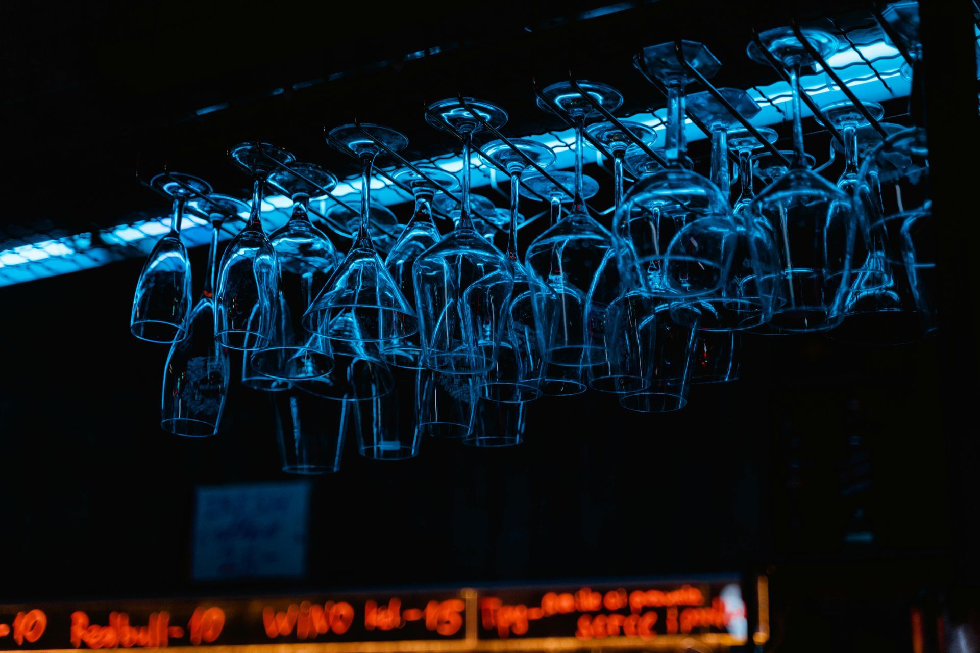 Boise Bar interior with stools, a long counter, and shelves filled with bottles, lit by amber lights.