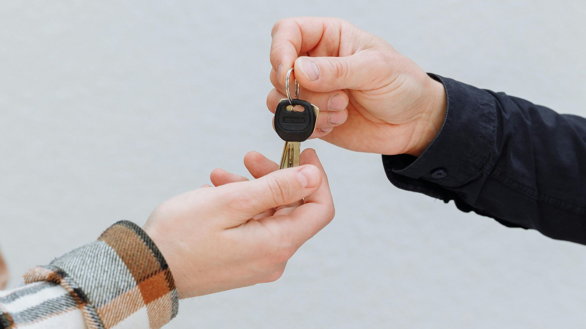 Person in Boise handing keys to another person and happy at Noble Clean Car Dealership Cleaning Services