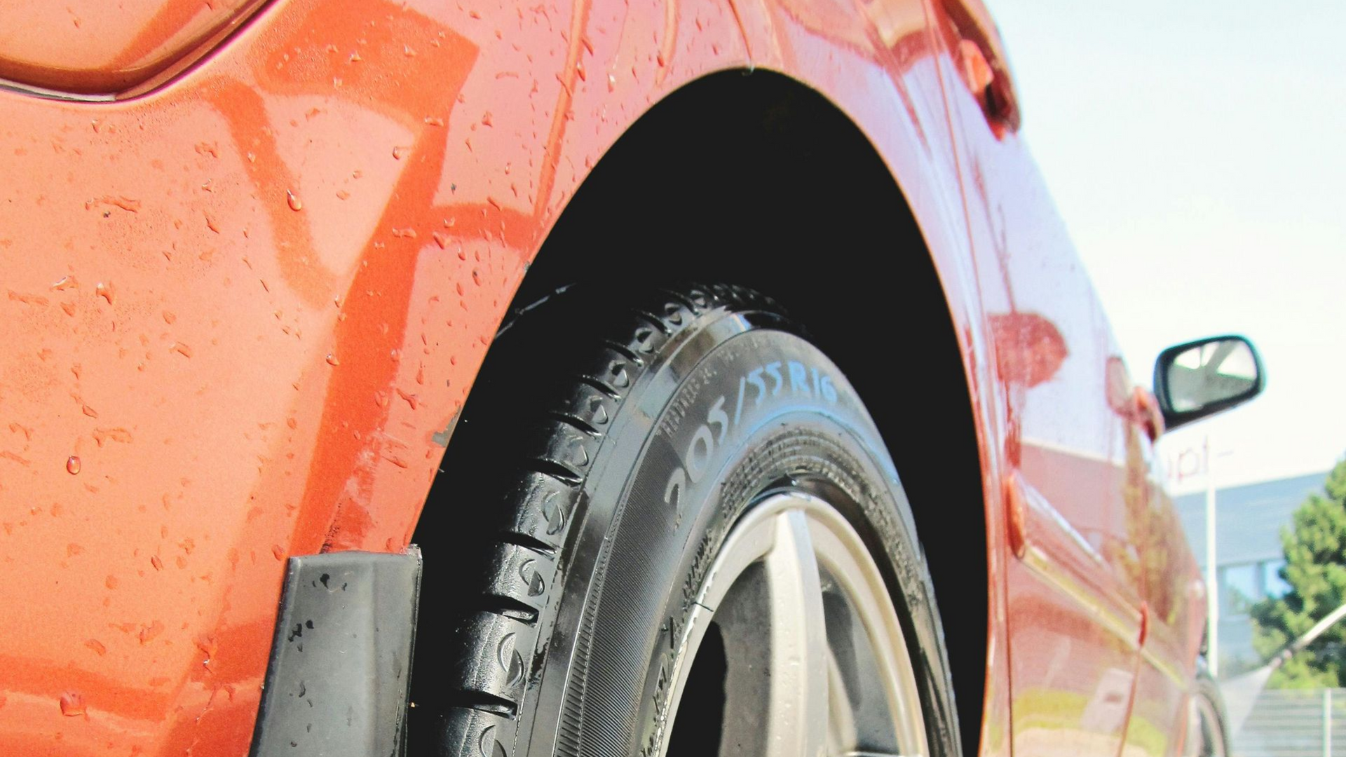 Red sports car's headlight and front quarter panel in Eagle, clean and shined by Noble Clean.