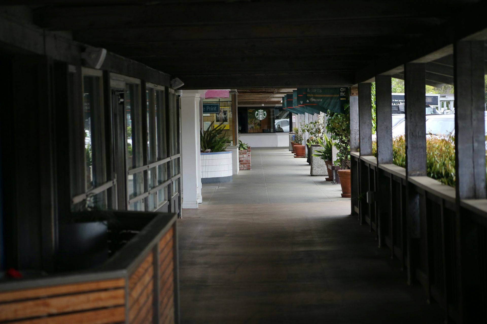 Warehouse interior with forklifts moving pallets, rows of storage racks, and concrete floor.