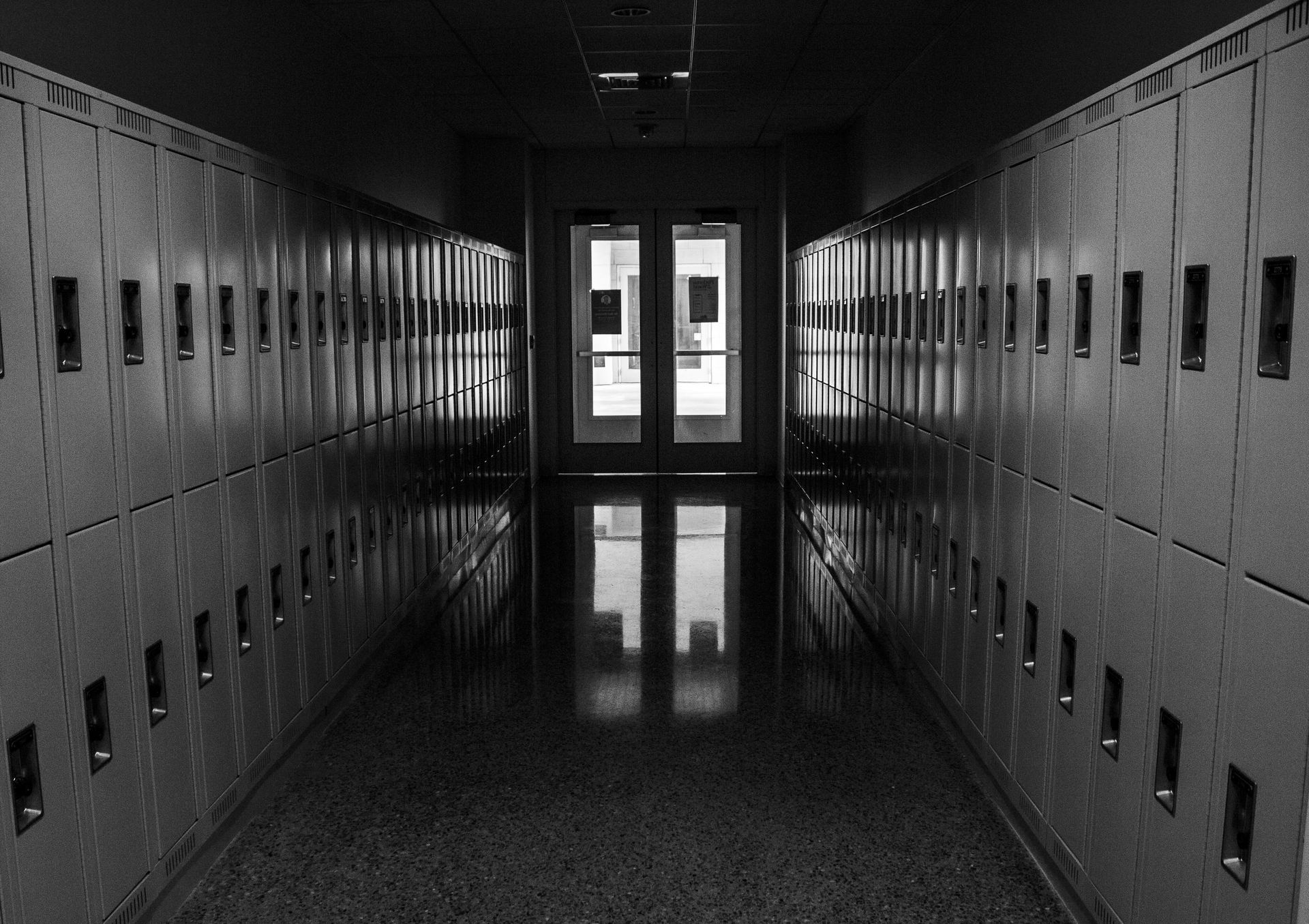 Rows of empty chairs face a stage in a large, empty conference room.