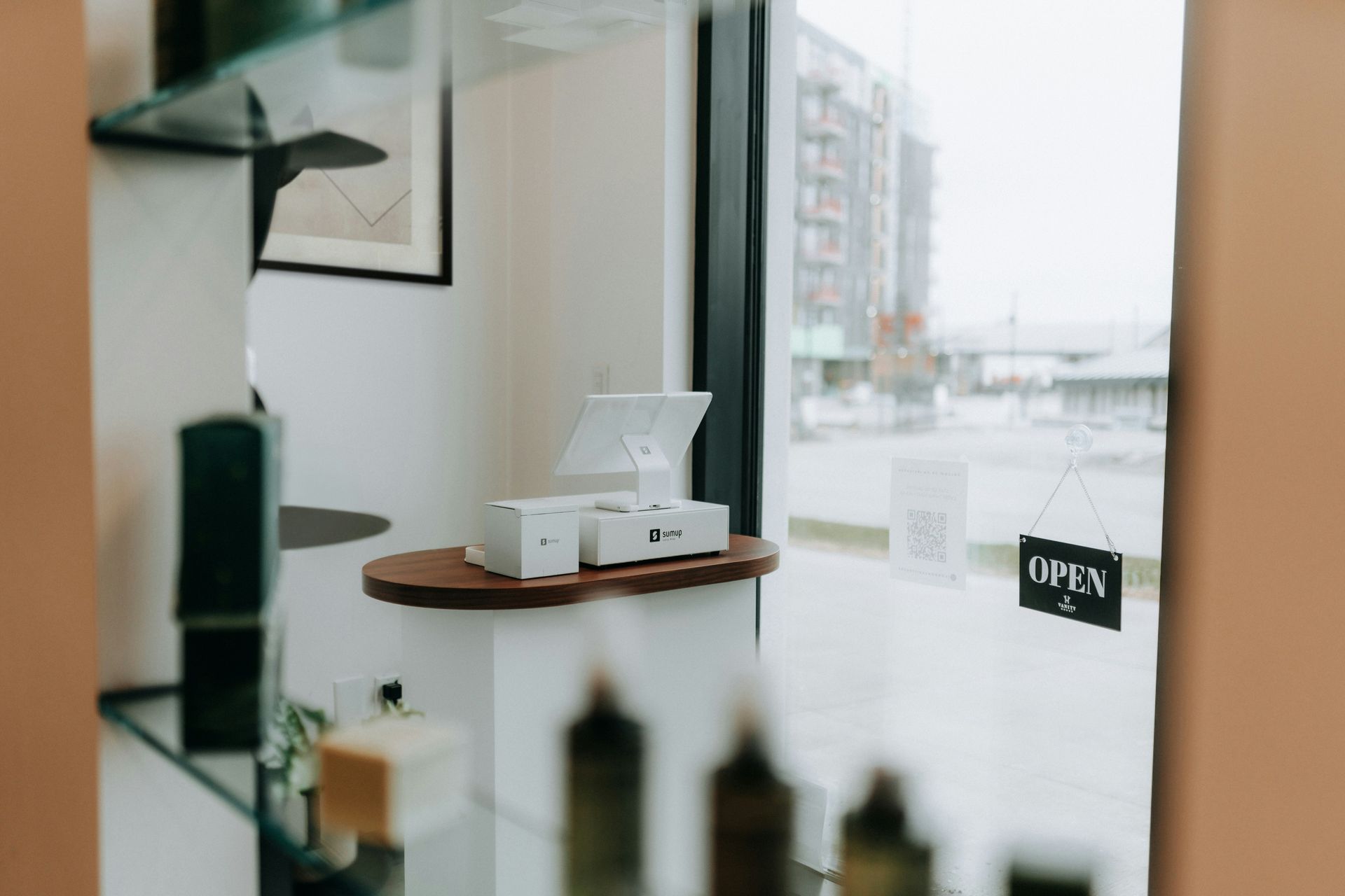 An open shop interior with a point-of-sale system on a counter by a window.