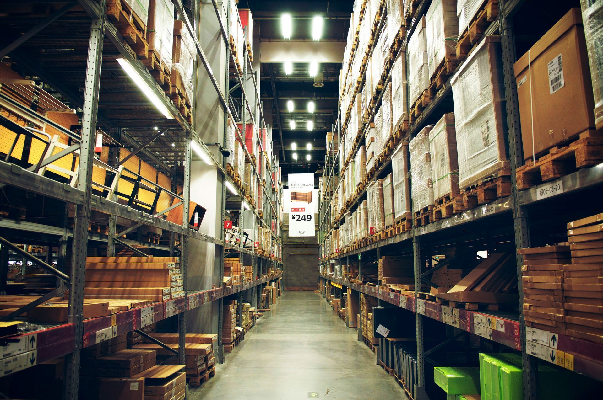 Warehouse aisle lined with shelves holding boxes and goods.