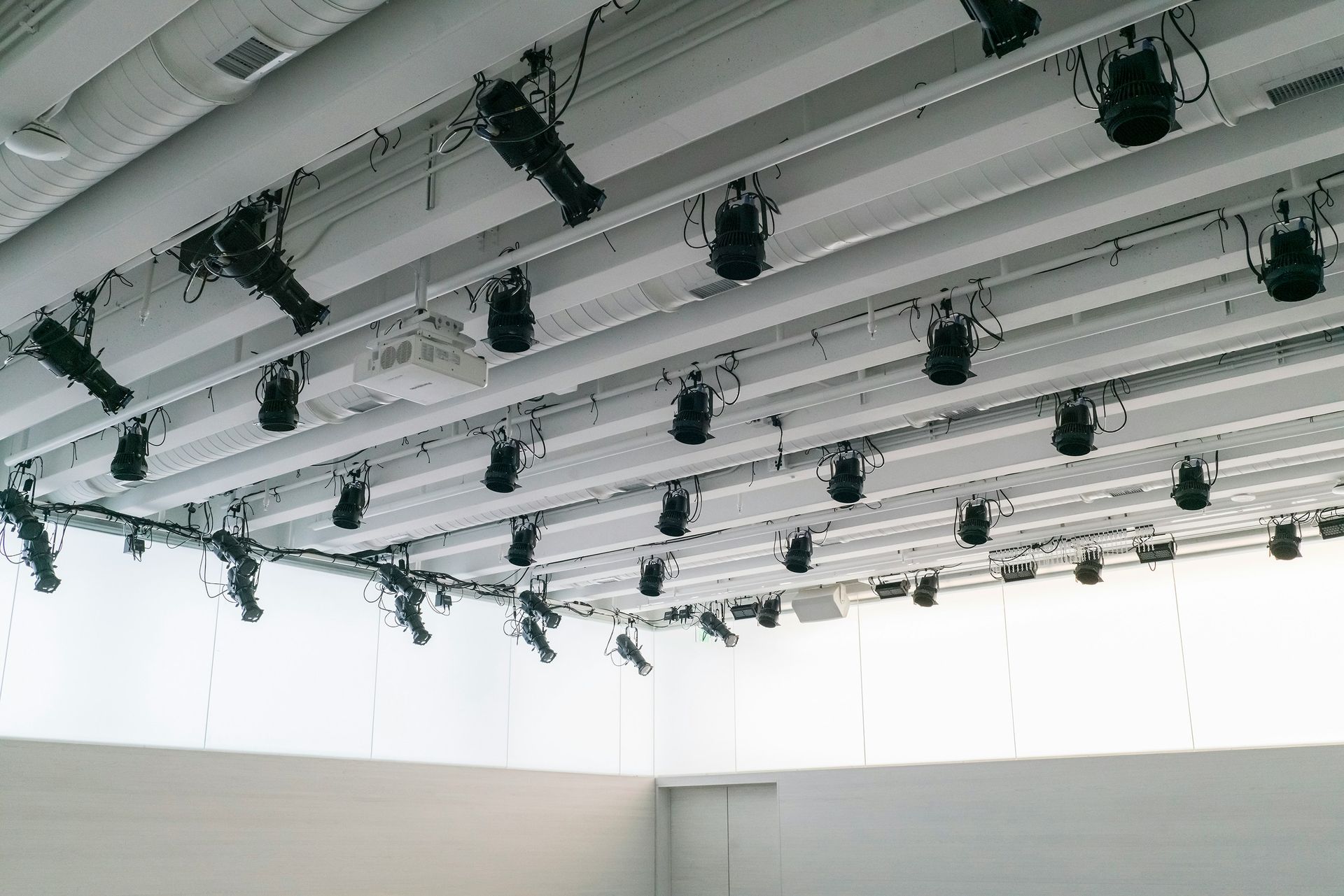 Empty classroom with rows of desks, windows, and natural light streaming in.