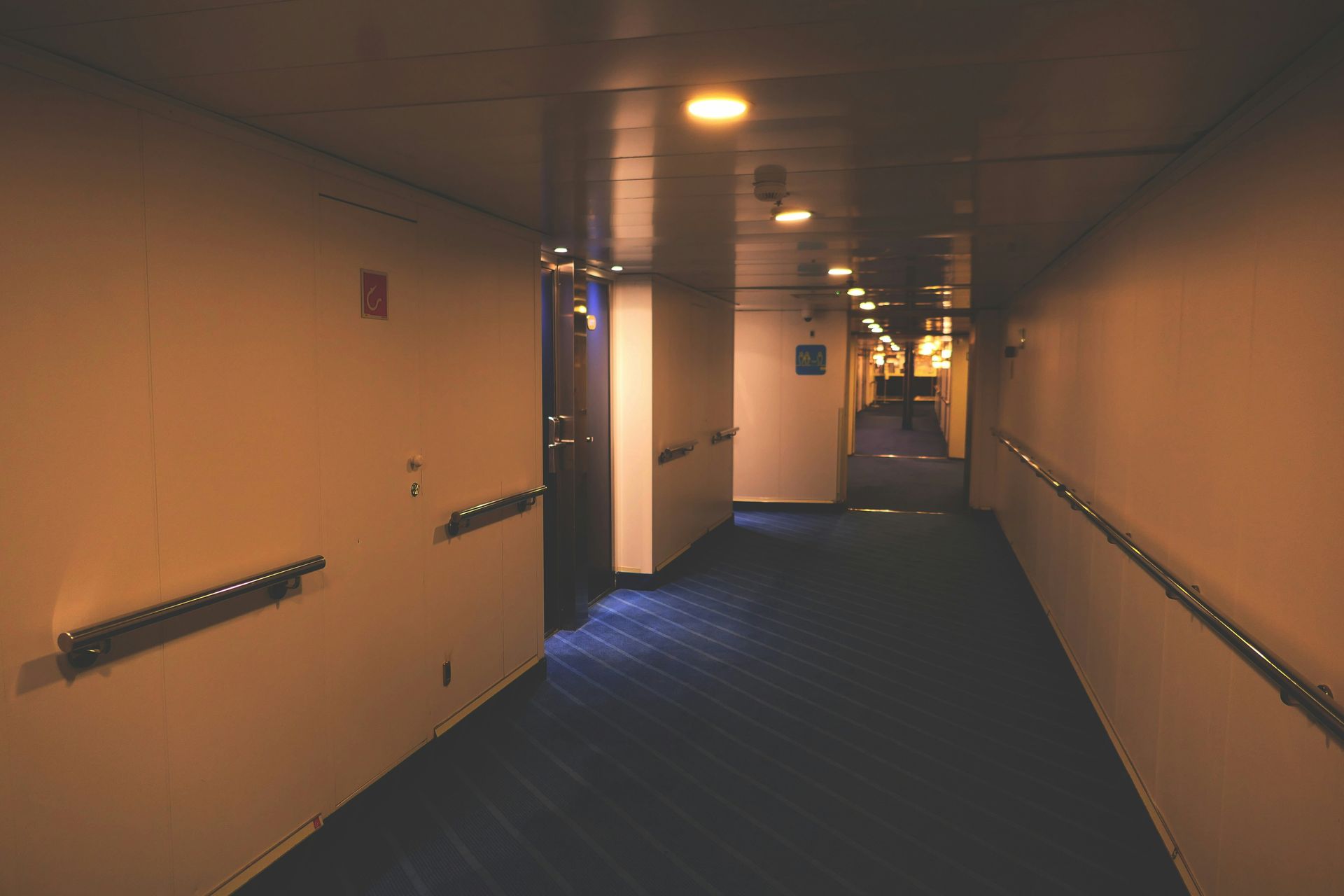 Warehouse interior with forklifts moving pallets, rows of storage racks, and concrete floor.