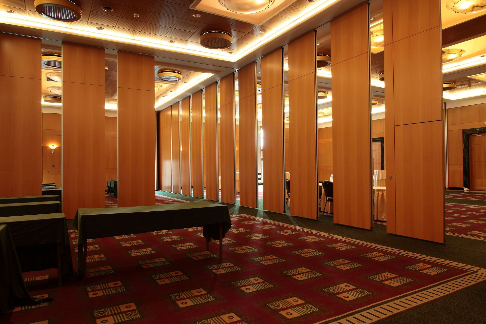 Rows of empty chairs face a stage in a large, empty conference room.