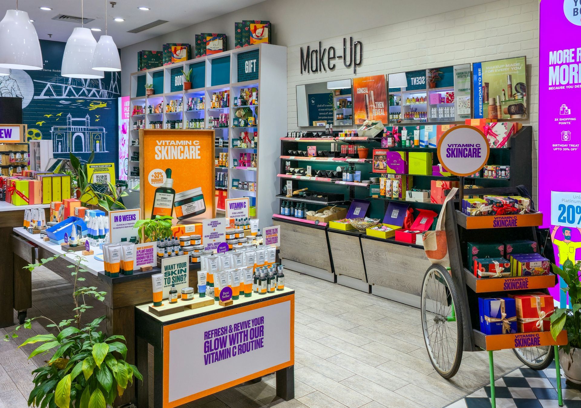 Interior of a bright cosmetics store with displays of products, including a colorful cart, and shelving units.
