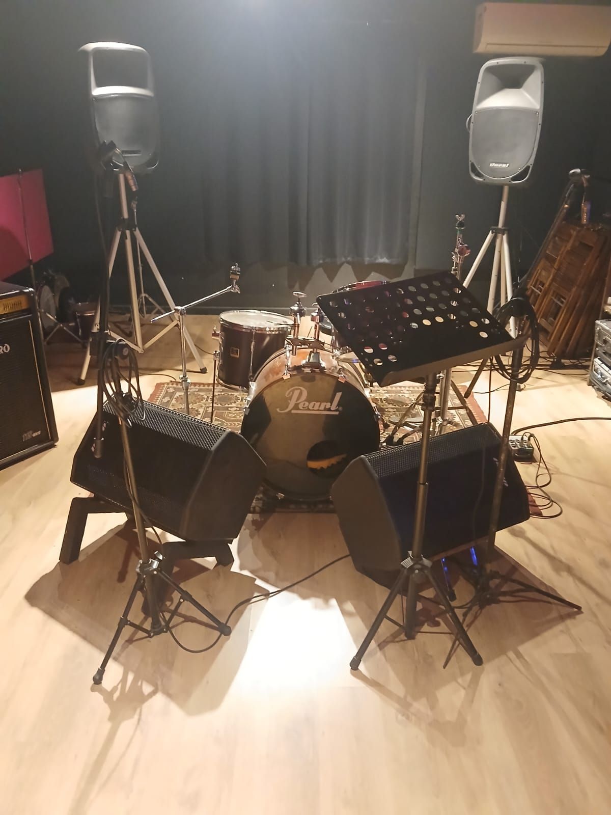 Uma bateria está sobre um piso de madeira em uma sala.