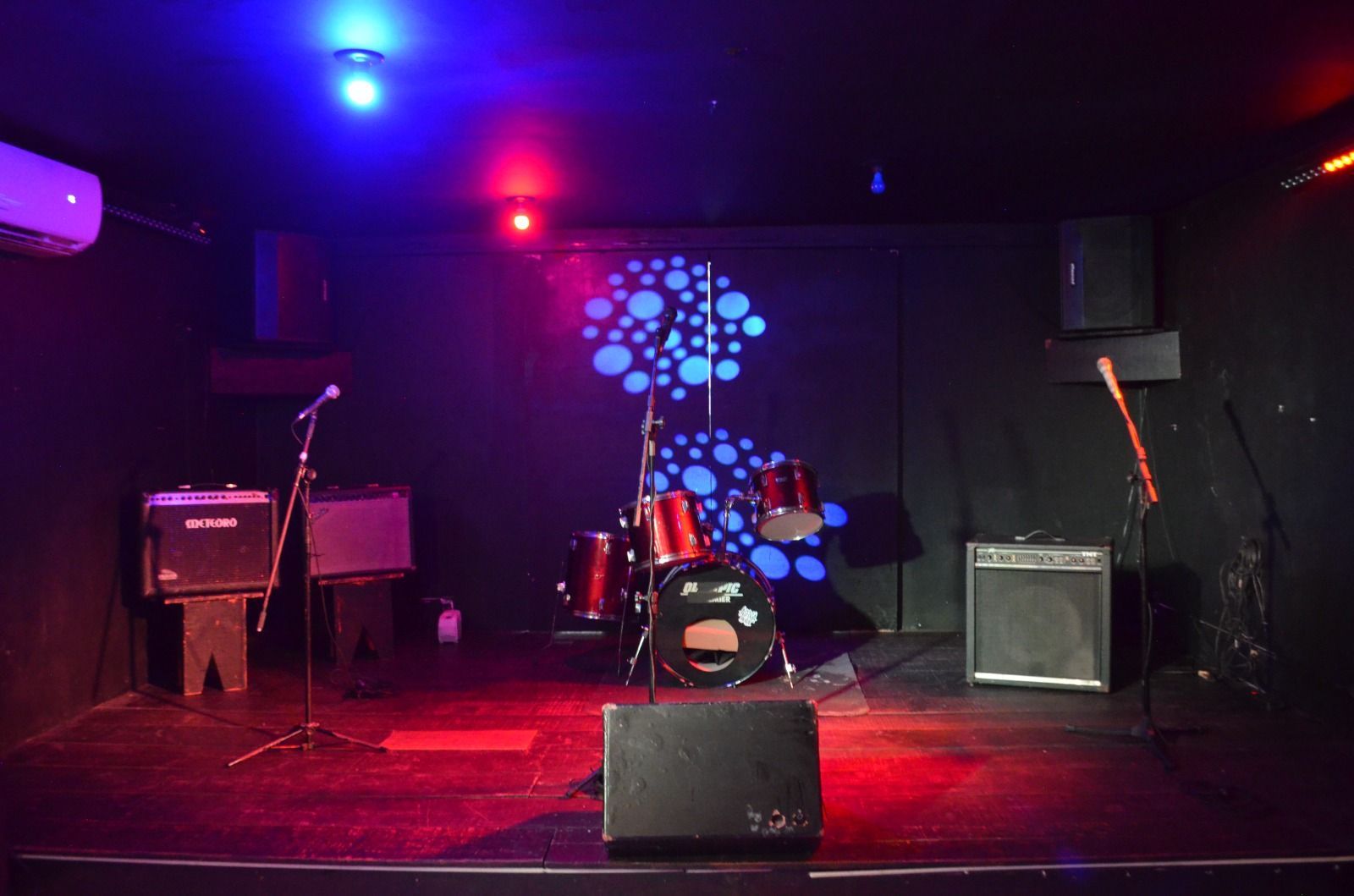 Um palco vazio com uma bateria e um microfone.