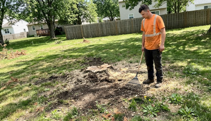 A professional tree care worker showing a smooth yard after stump removal Charlottesville services.