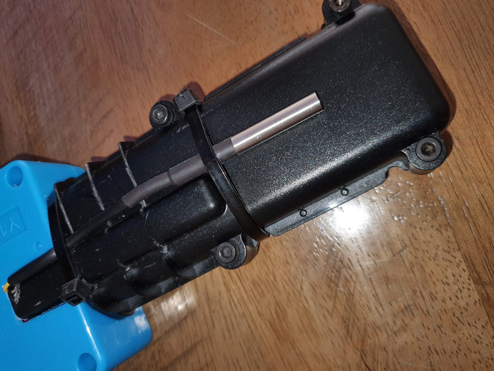 חפץ שחור מונח על שולחן עץ.