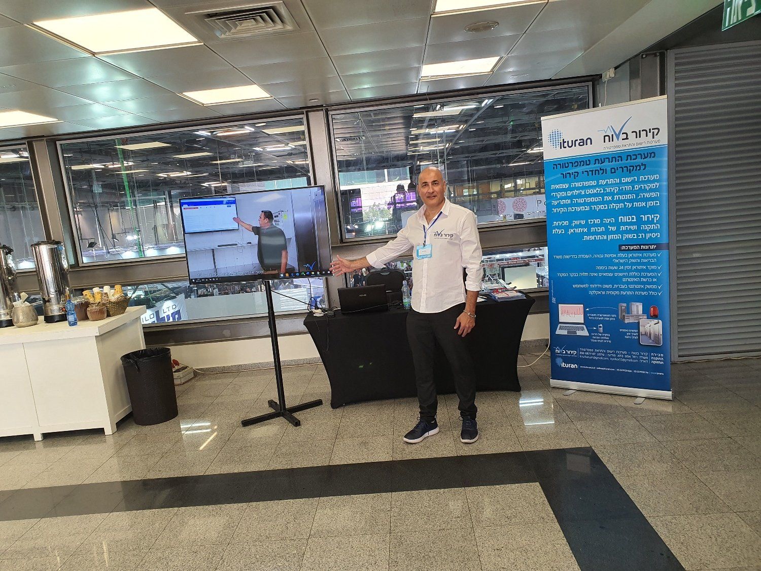 גבר עומד מול שלט בחדר.