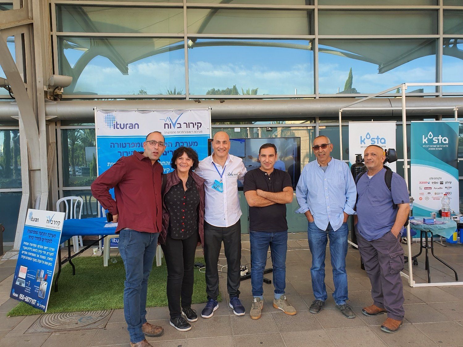 קבוצת אנשים מצטלמת מול בניין.