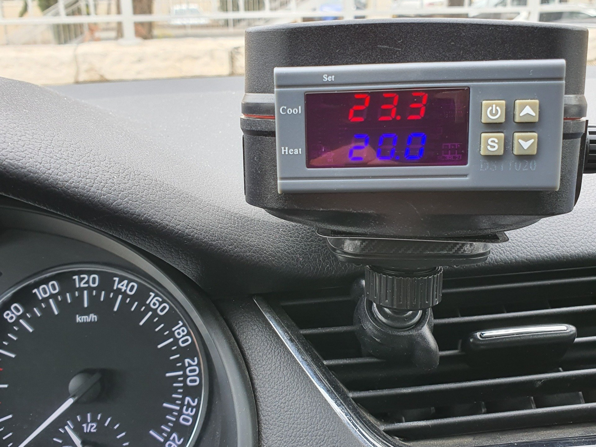 לוח מחוונים של מכונית עם מד מהירות ומדחום שמציג 23.3