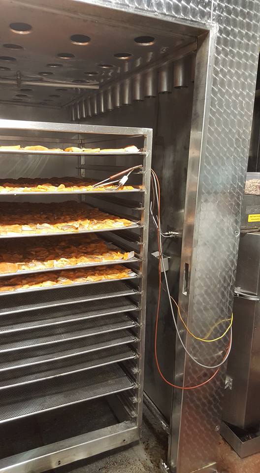 מדף נירוסטה מלא במגשי אוכל במטבח.