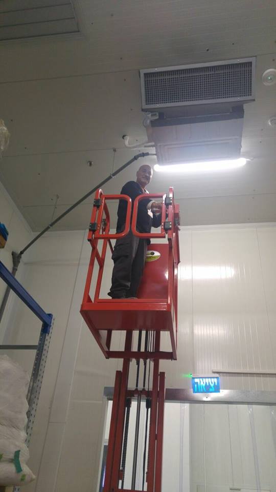 גבר עומד על מעלית בחדר.