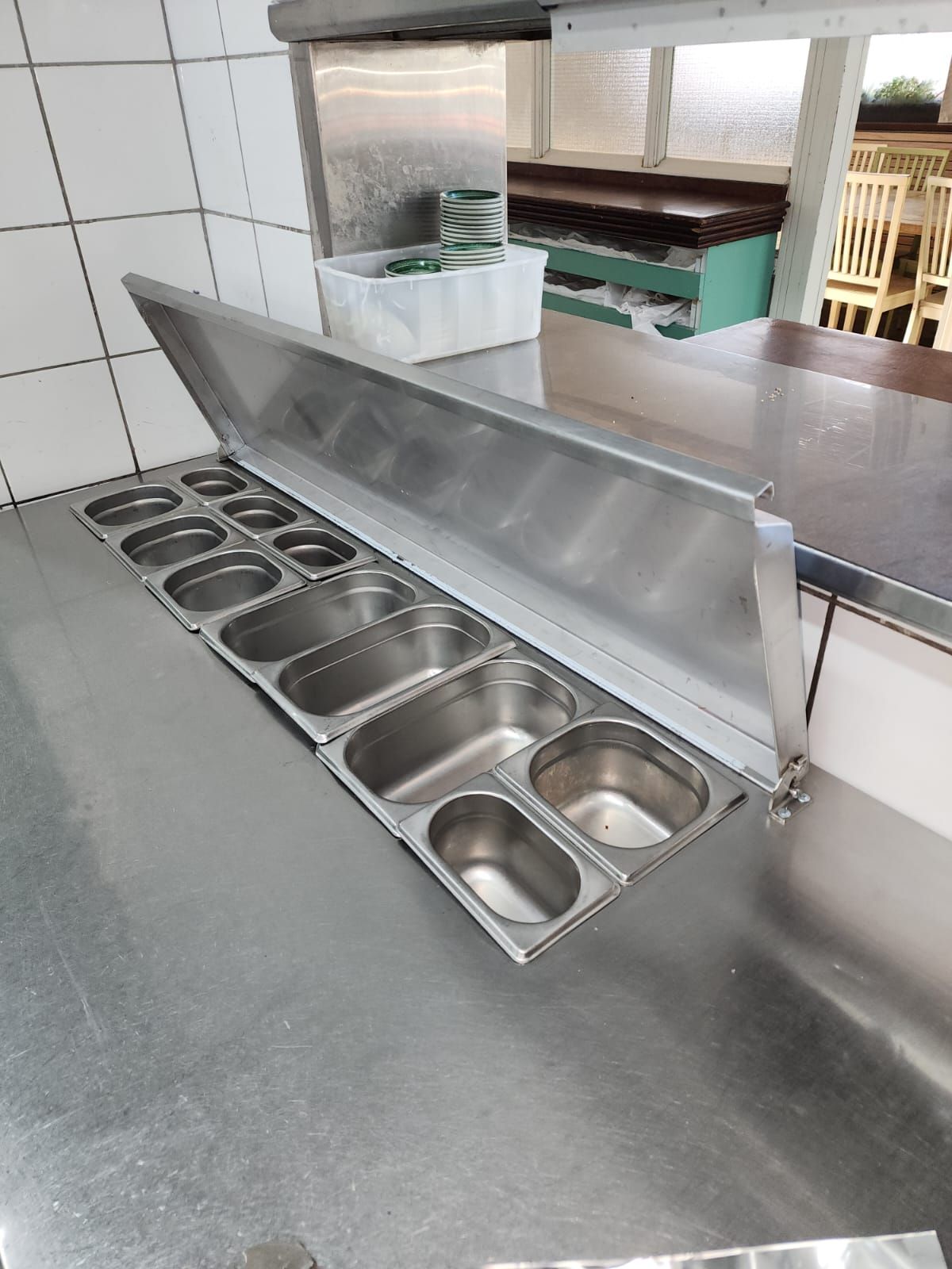 דלפק נירוסטה עם הרבה מיכלים עליו.