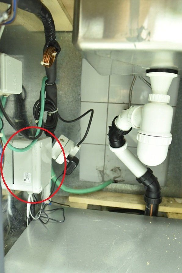 צינור לבן עם עיגול אדום סביבו נמצא מתחת לכיור