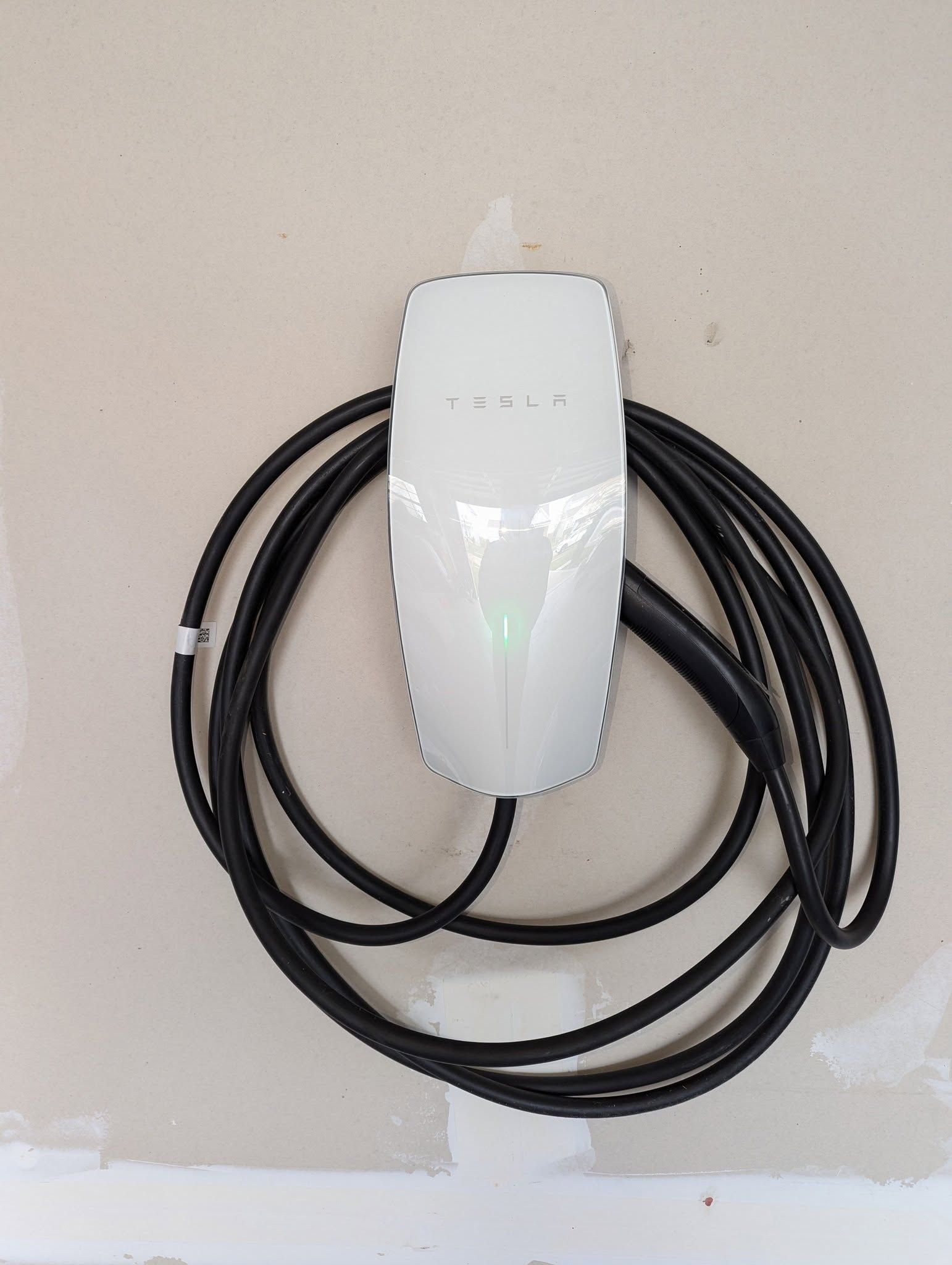 A tesla charging station with a cable attached to it