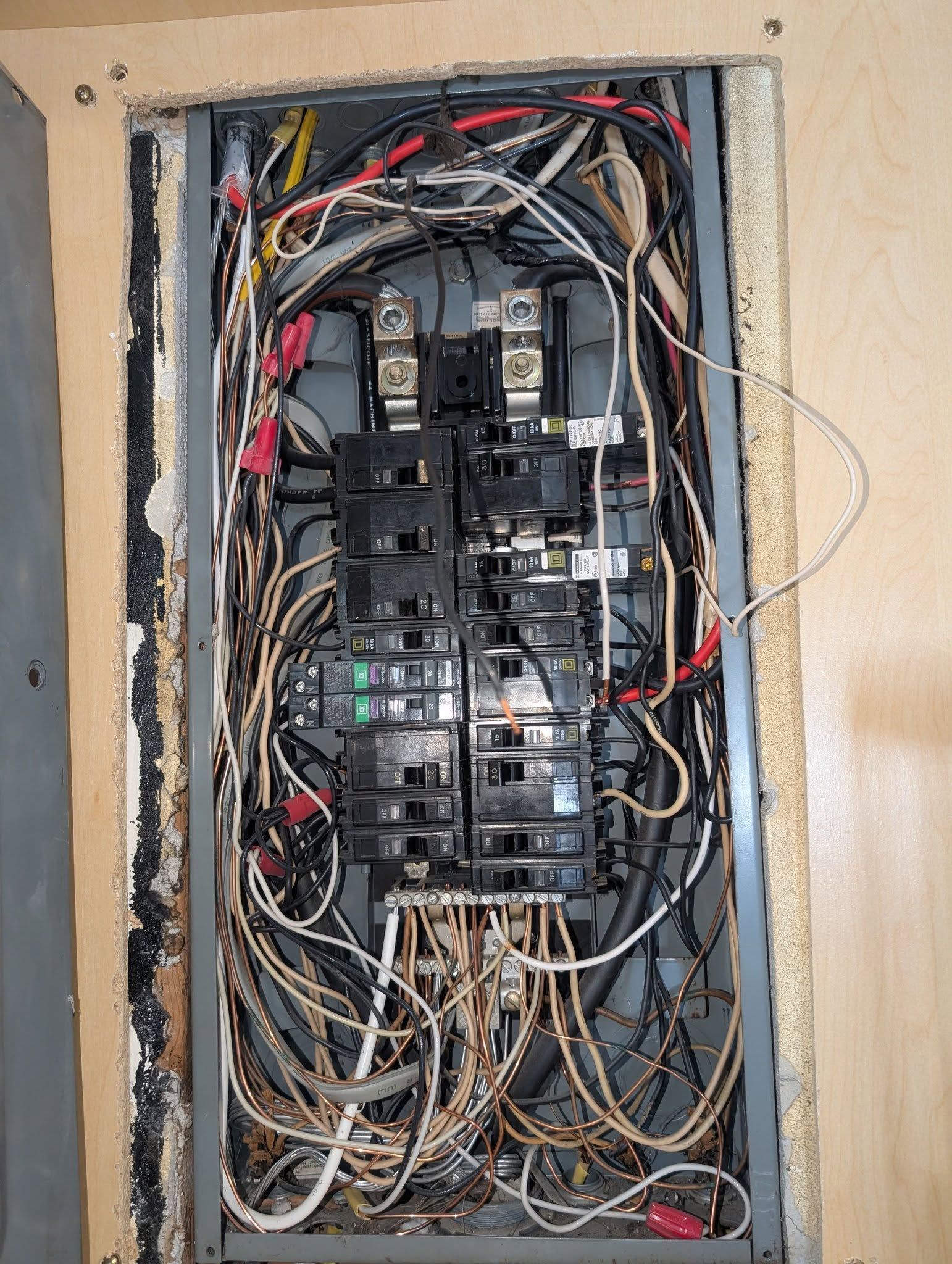 A very messy electrical box with a lot of wires coming out of it.