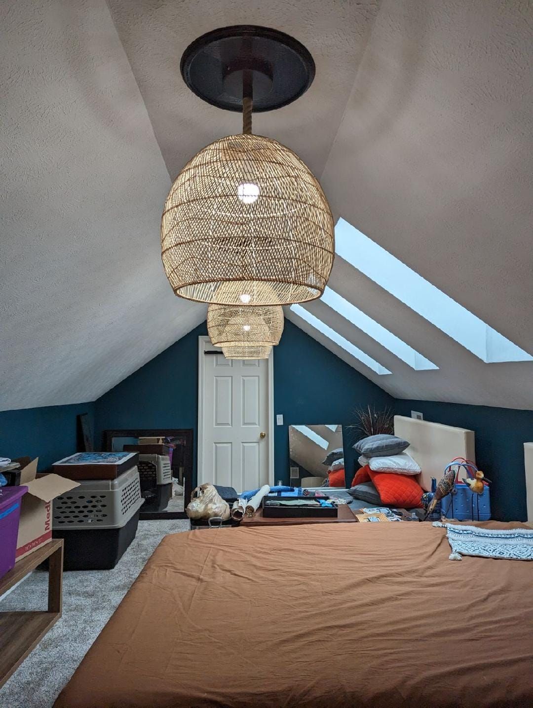A bedroom with a large bed and a light hanging from the ceiling