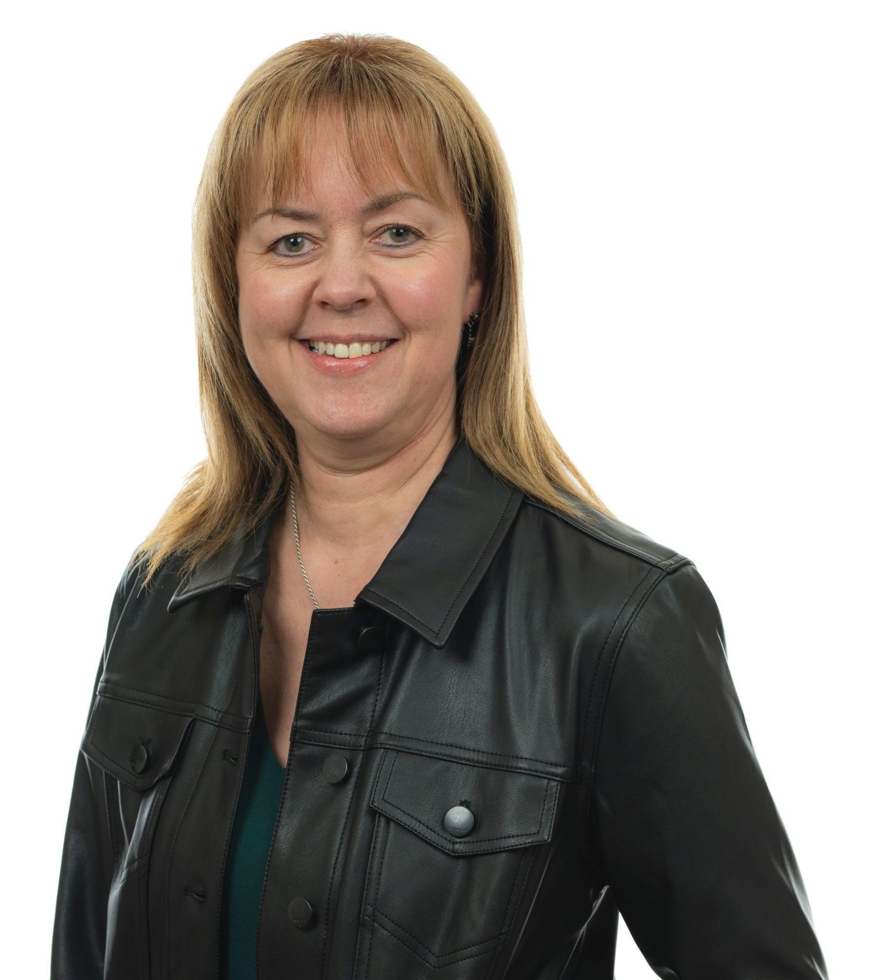 Une femme portant une veste en cuir noir sourit à la caméra