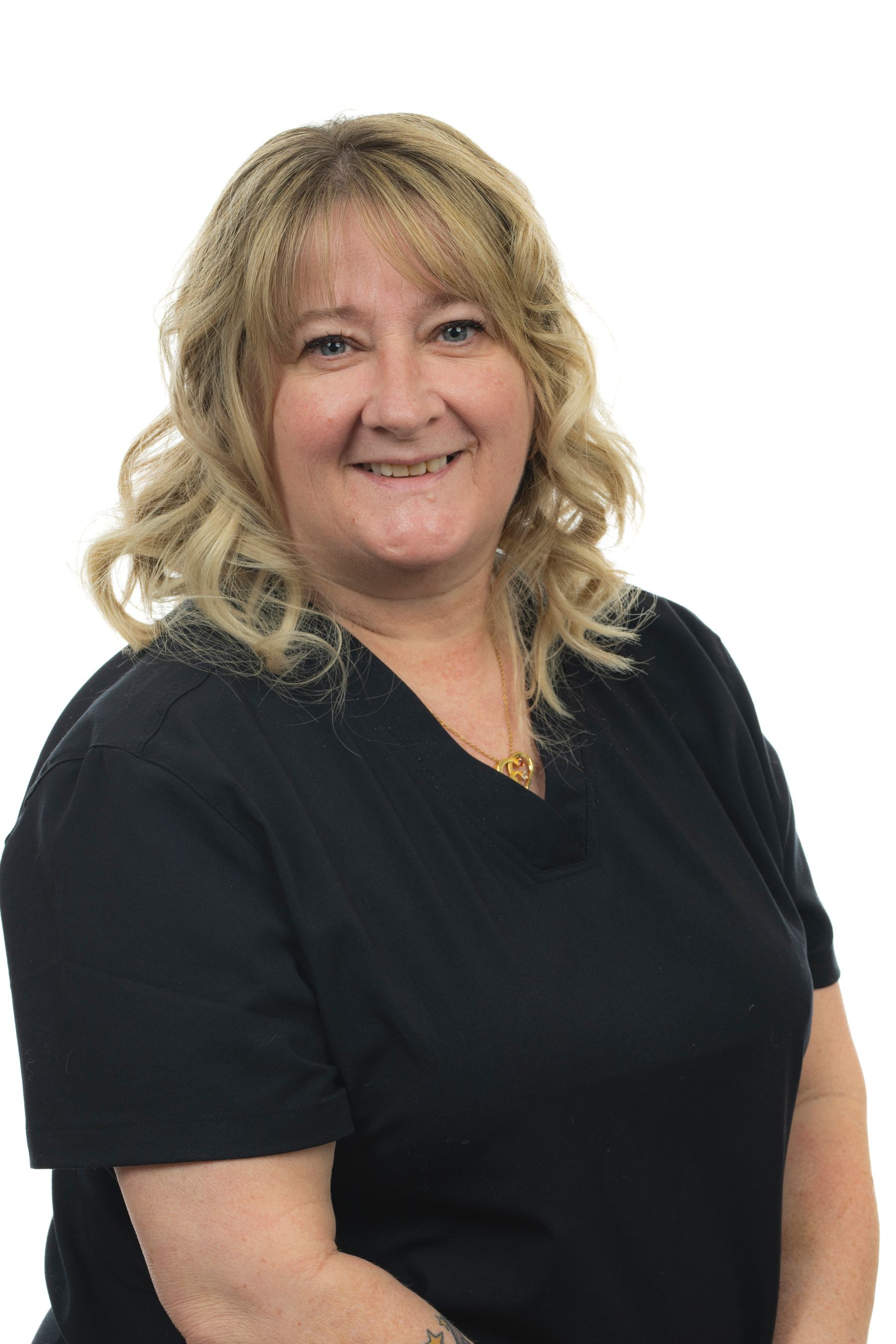 Une femme vêtue d'un haut noir sourit à la caméra.