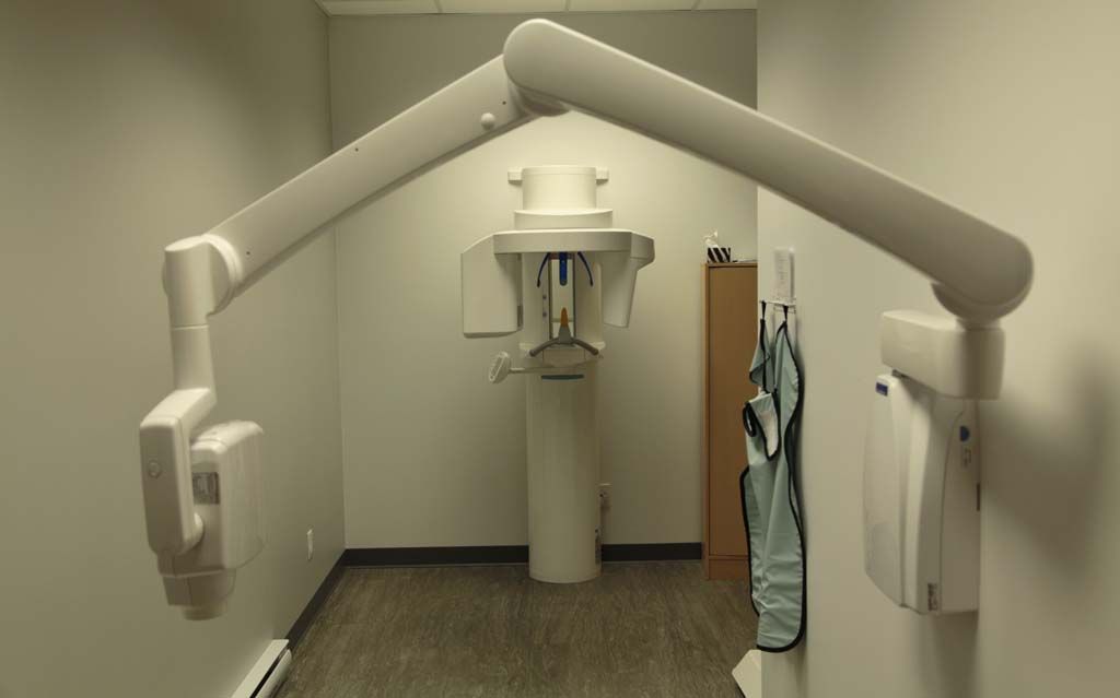 Une pièce avec un appareil de radiographie dentaire sur le mur.
