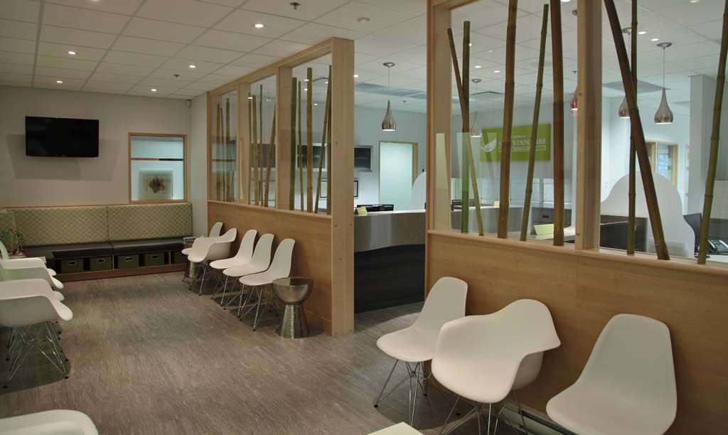 Une salle d'attente avec des chaises blanches et une cloison en bois