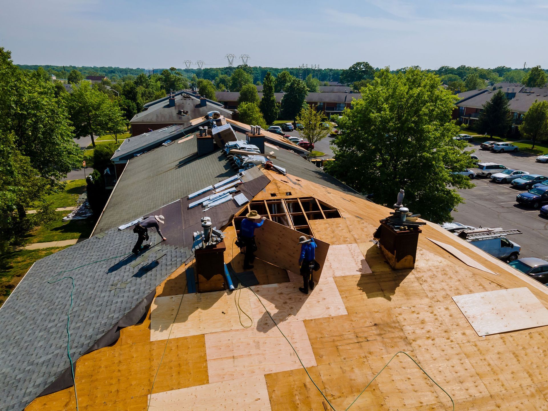Experienced roofers handling an emergency roofing repair on a residential apartment building.