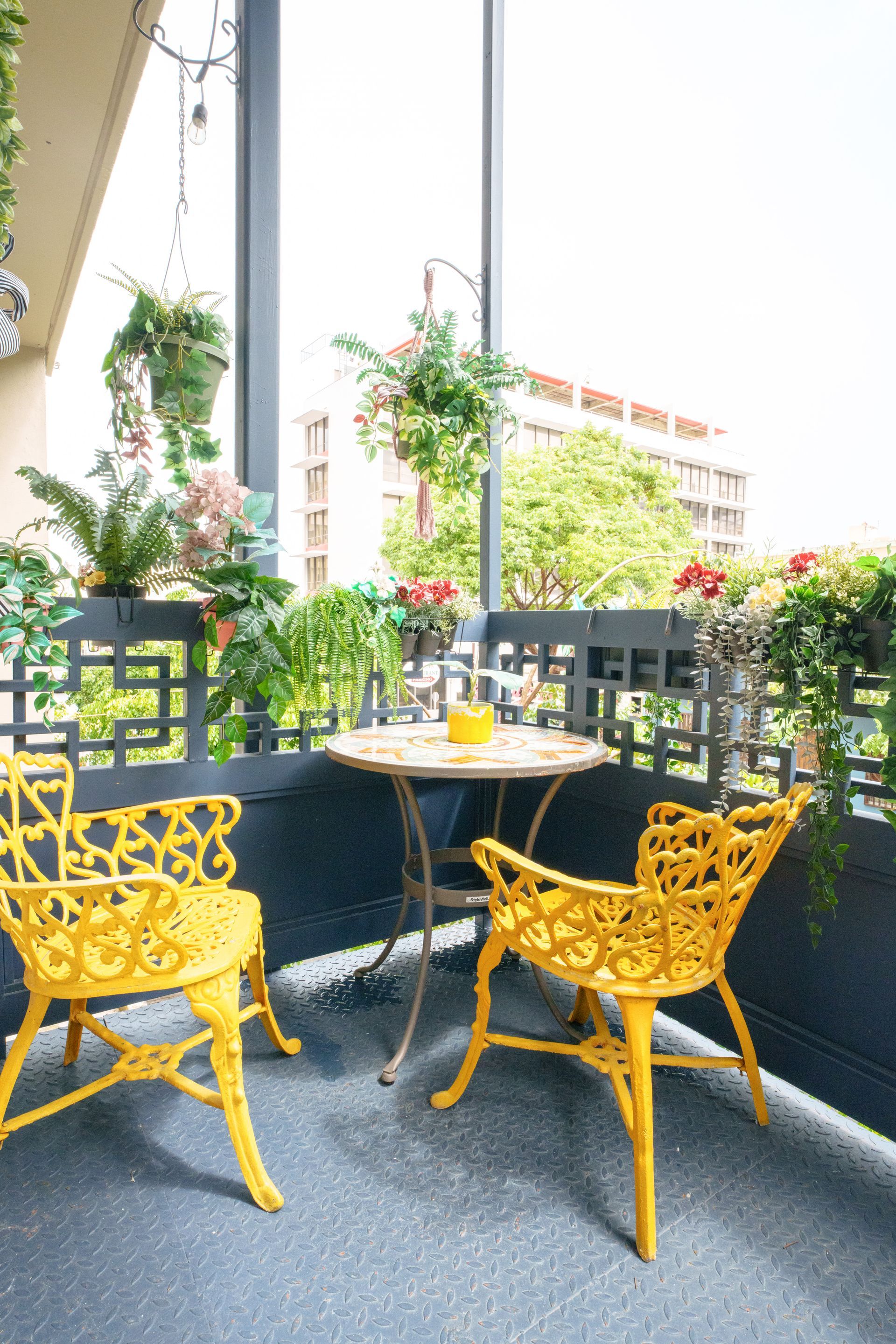 A balcony with two yellow chairs and a table Somos Hotel San Juan, Puerto Rico Avenida Ponce de Leon