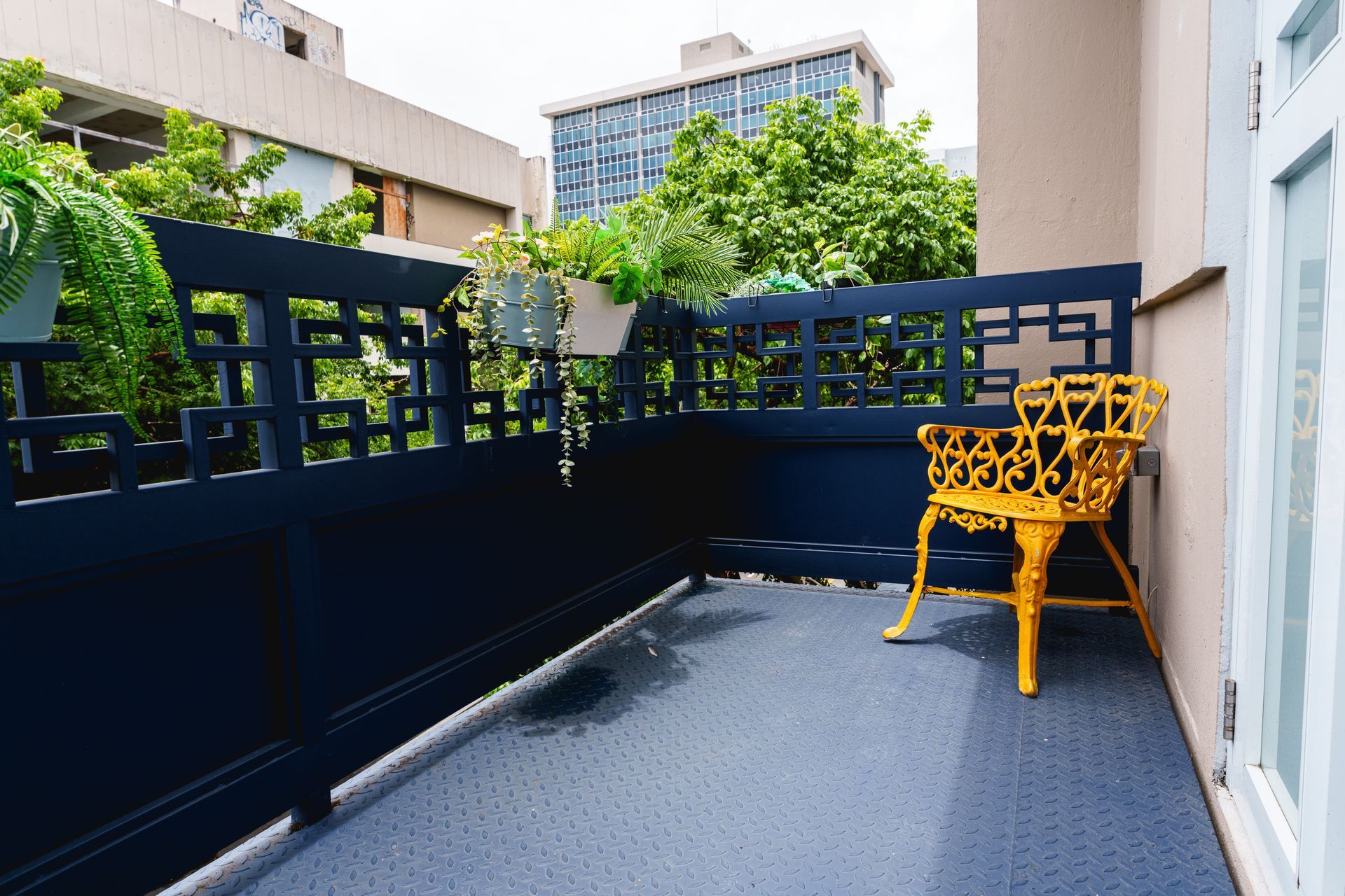 A balcony with a yellow chair and a black fence Somos Hotel San Juan, Puerto Rico Avenida Ponce de Leon