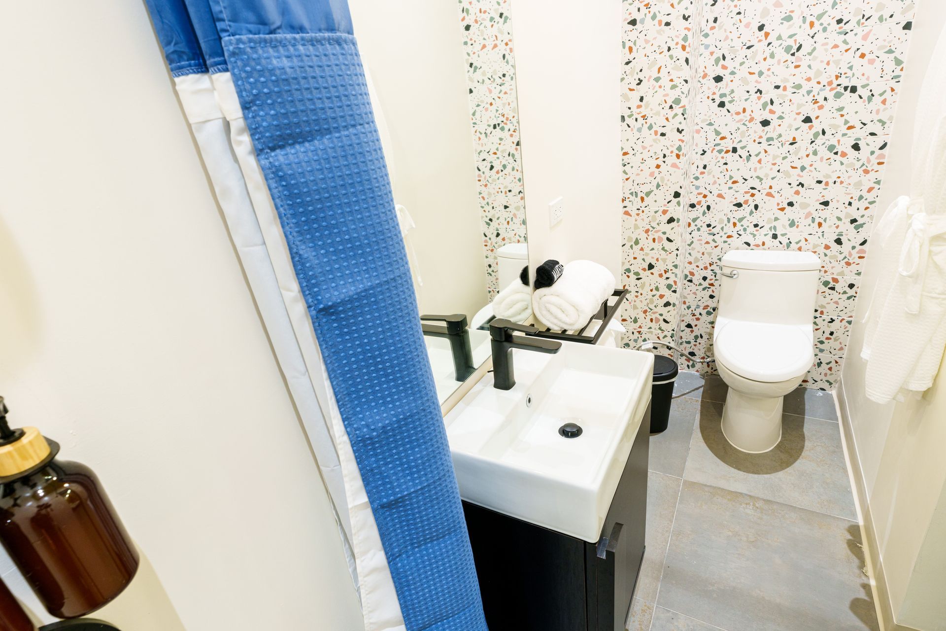 A bathroom with a sink , toilet and shower curtain. Somos Hotel San Juan, Puerto Rico Avenida Ponce de Leon