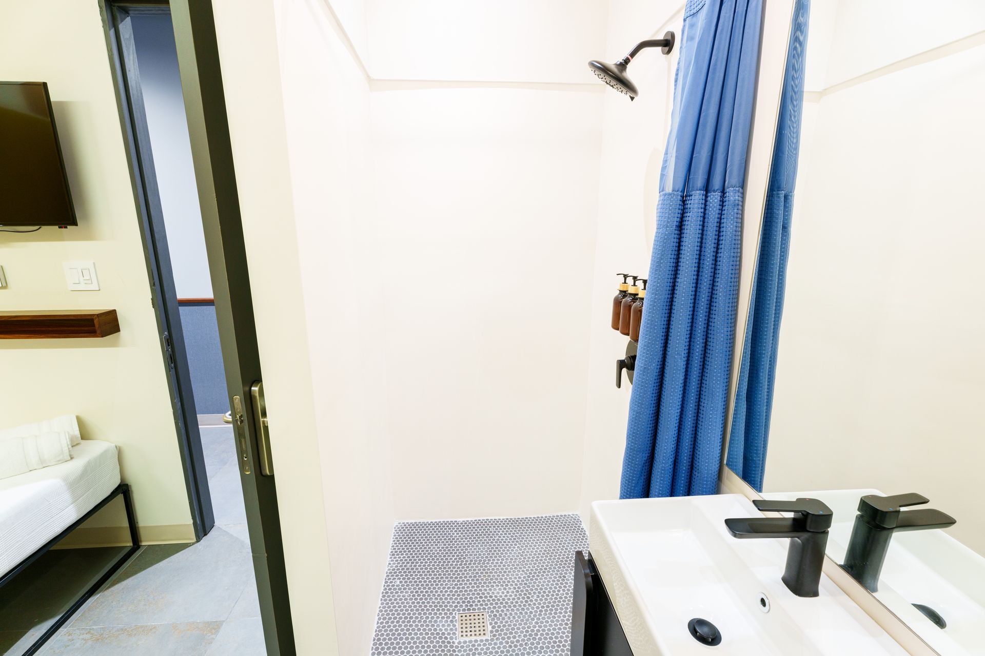 A bathroom with a sink , mirror and shower. Somos Hotel San Juan, Puerto Rico Avenida Ponce de Leon