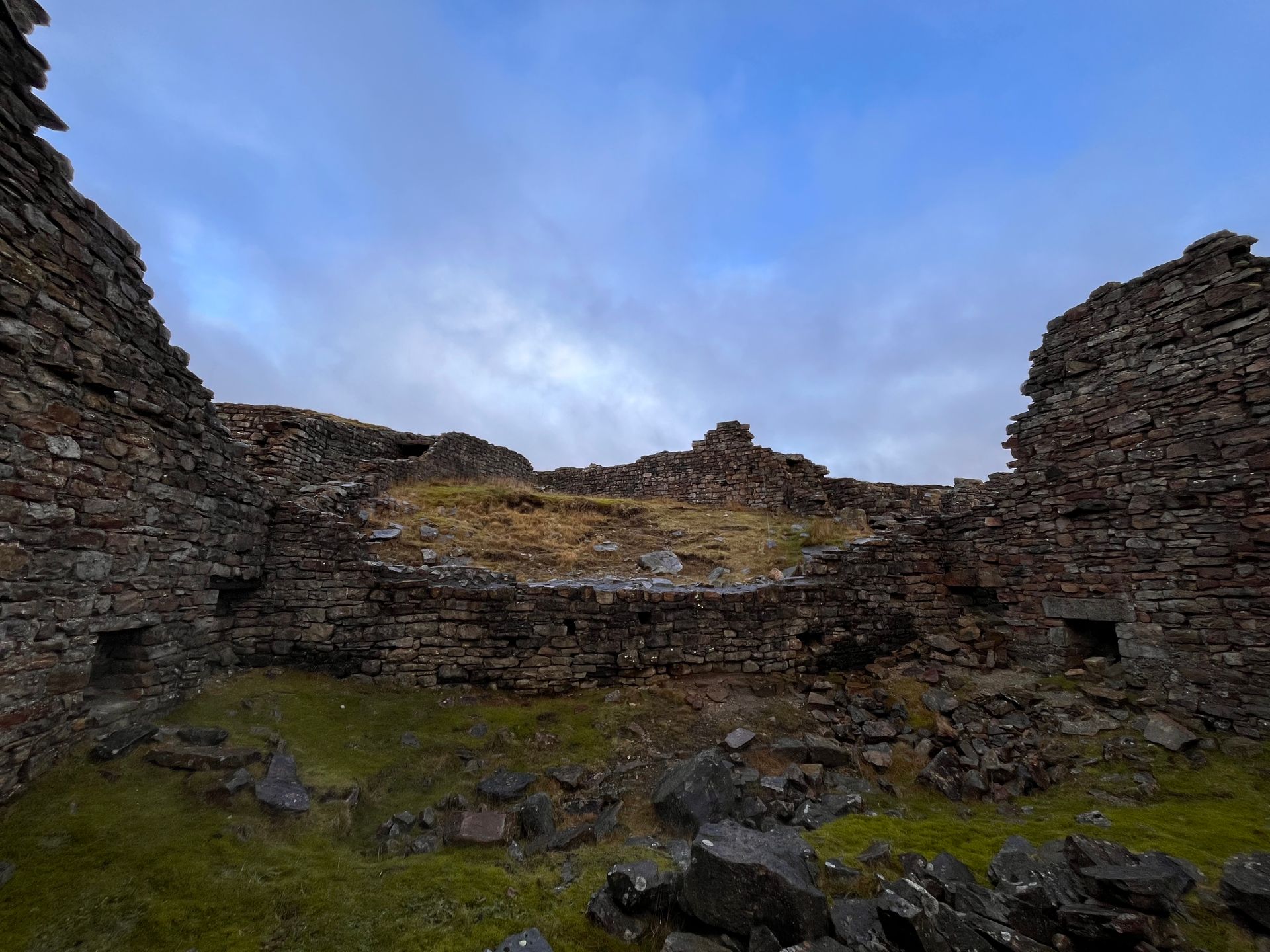 A ruined building with a blue sky in the background.