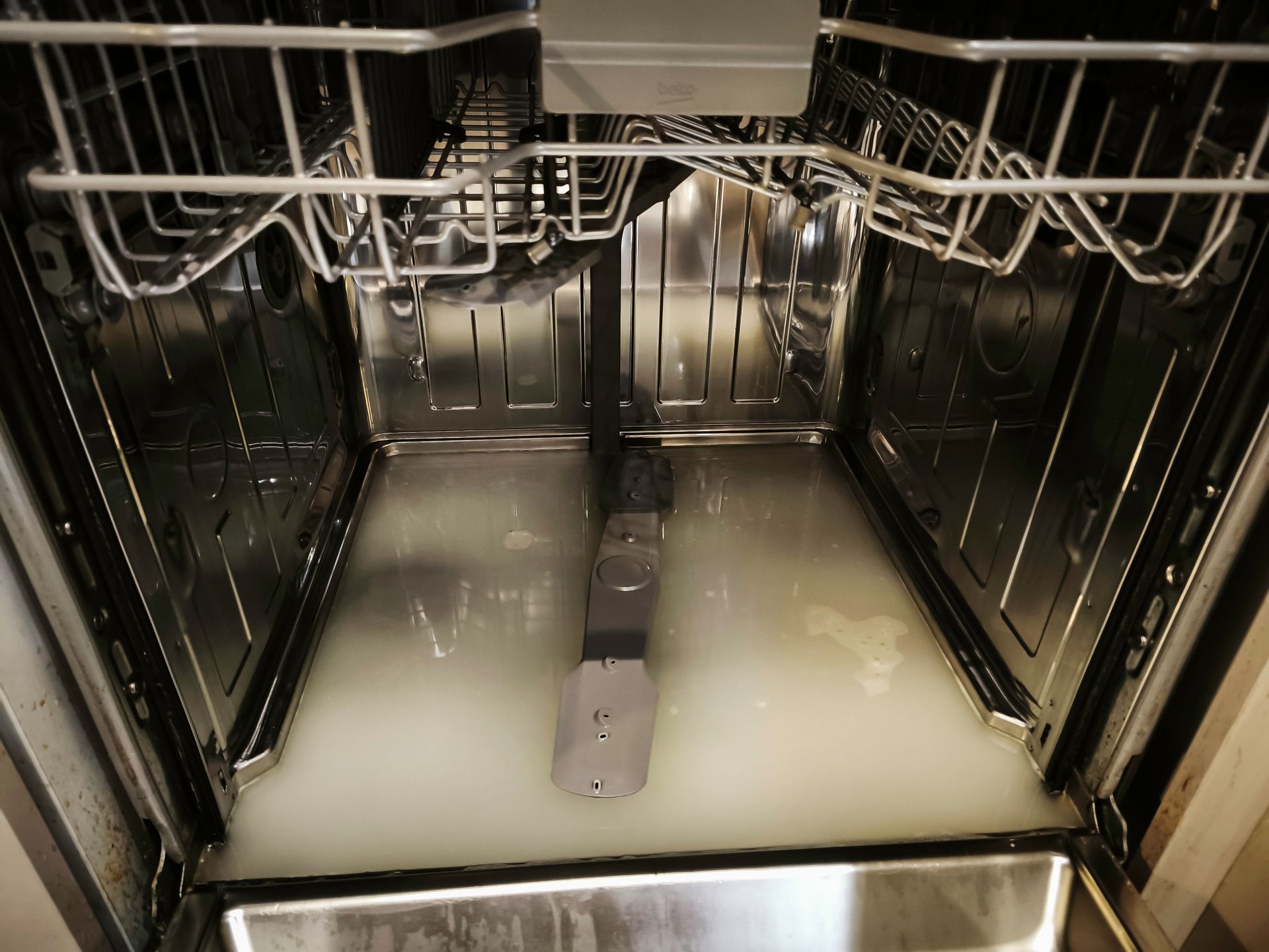 Modern kitchen with stainless steel appliances, white cabinets, and black countertops.