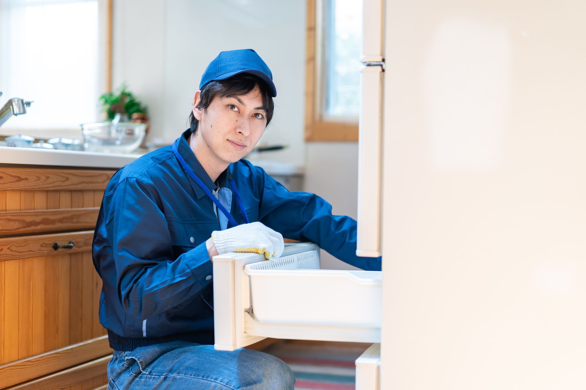 Open dishwasher with tools scattered on the floor; repair in progress.